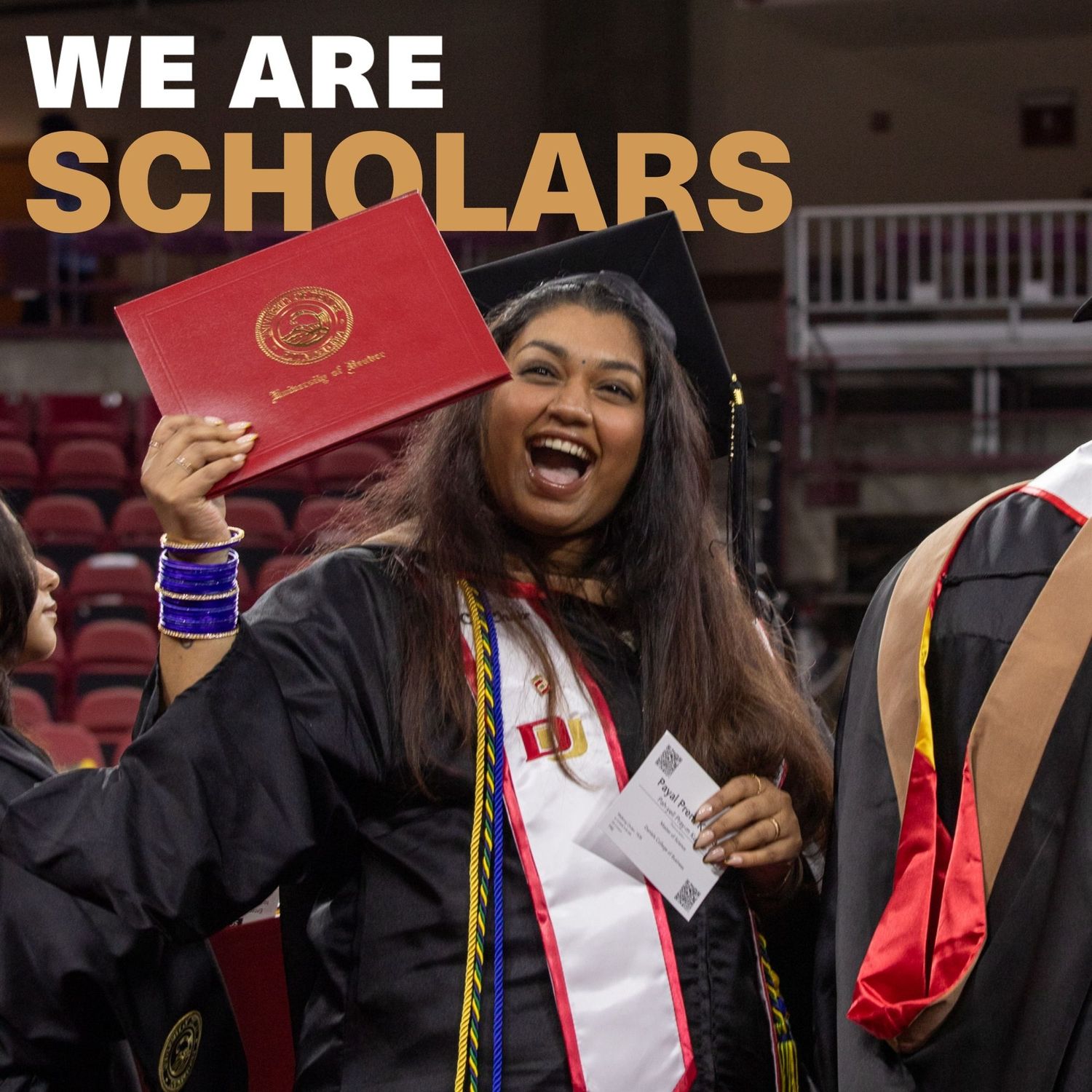 Joyful graduate in black cap and gown holds red diploma at university commencement ceremony with We Are Scholars text.