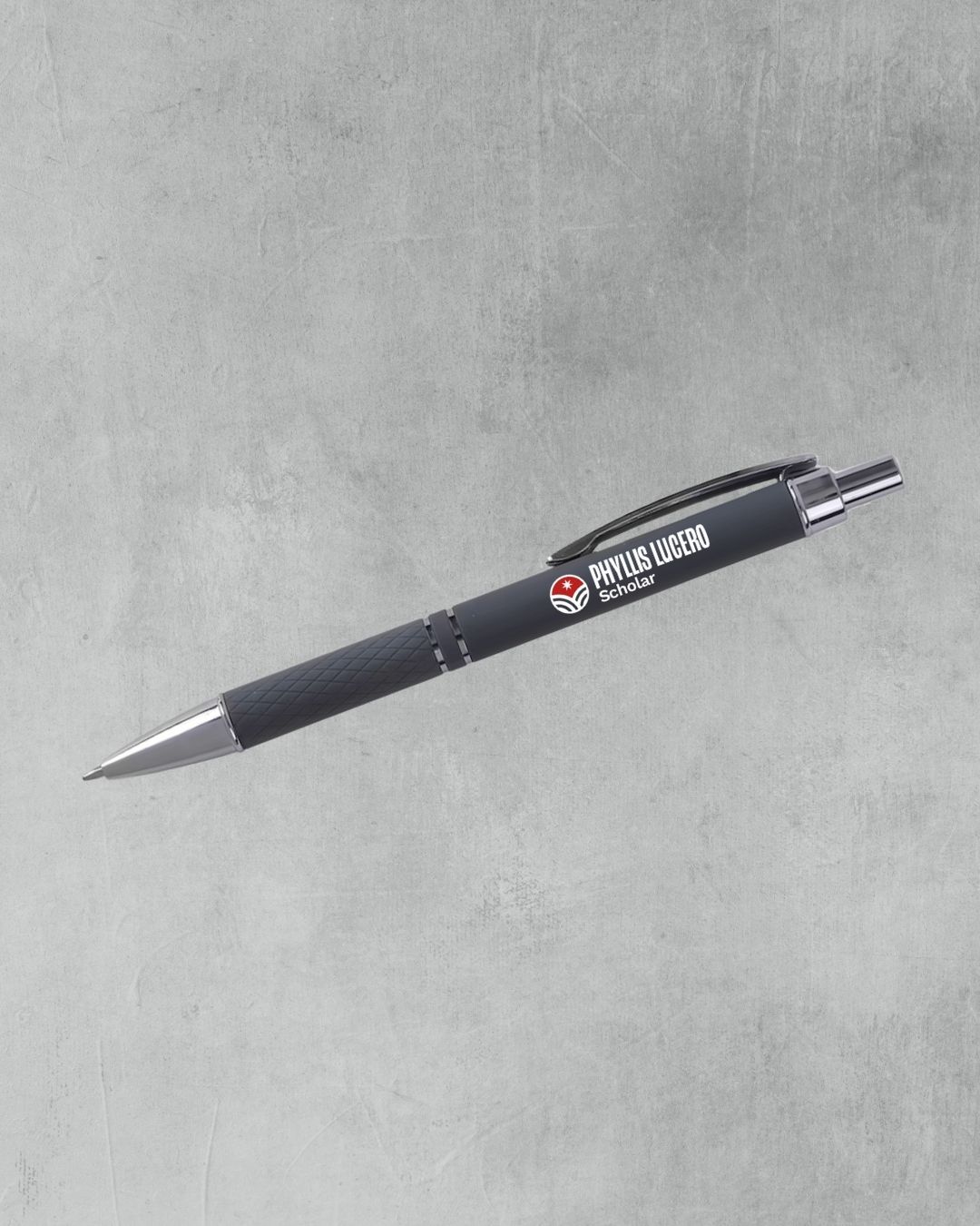 Black retractable ballpoint pen with silver accents and Phyllis Lufero branding logo on gray background.