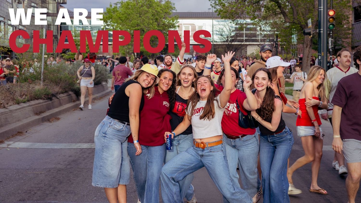 Group of young women celebrating a championship win outdoors, with 'We Are Champions' text overlay.