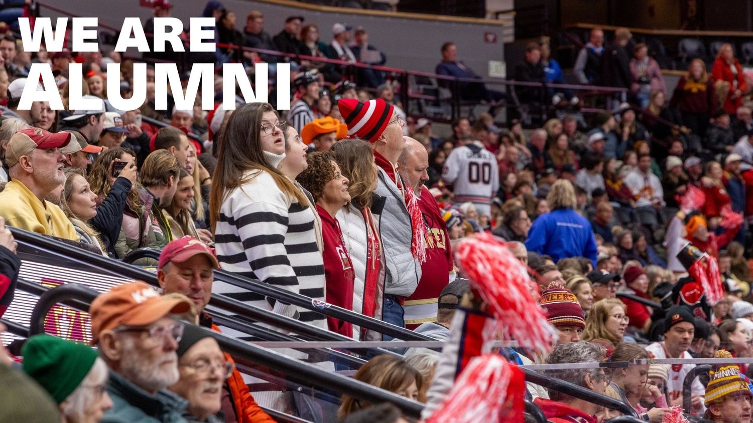 Excited alumni crowd cheering at a university sports event with We Are Alumni text overlay.