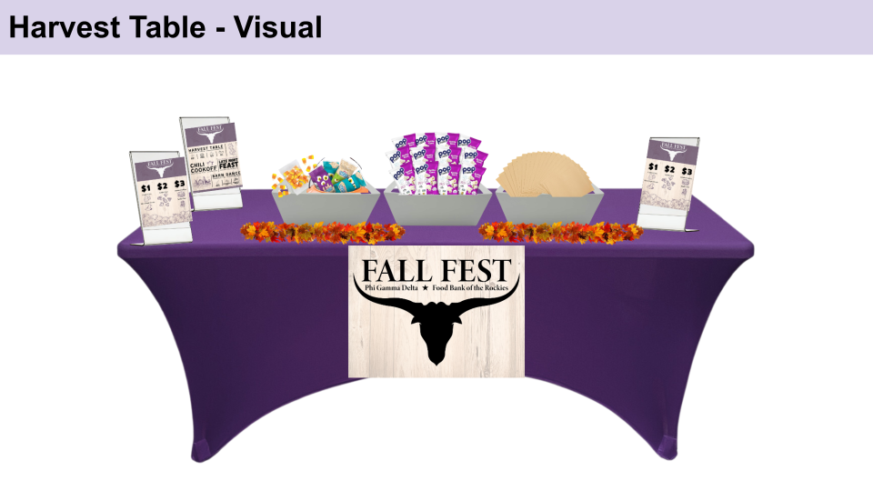A purple harvest-themed table display with decorative elements arranged for a fall festival event.