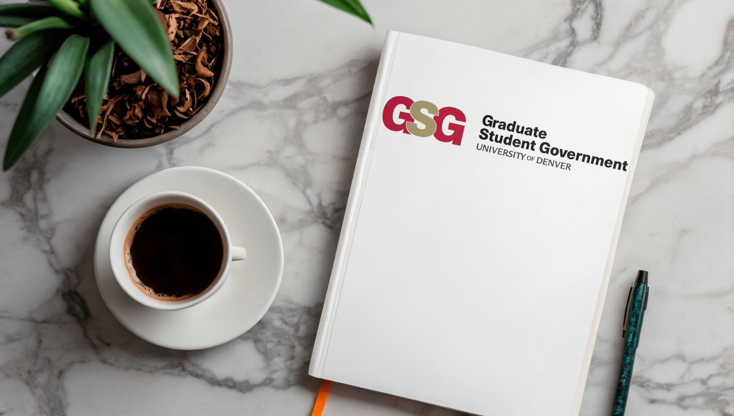 ESG business notebook with coffee cup and green plant on marble desk surface.