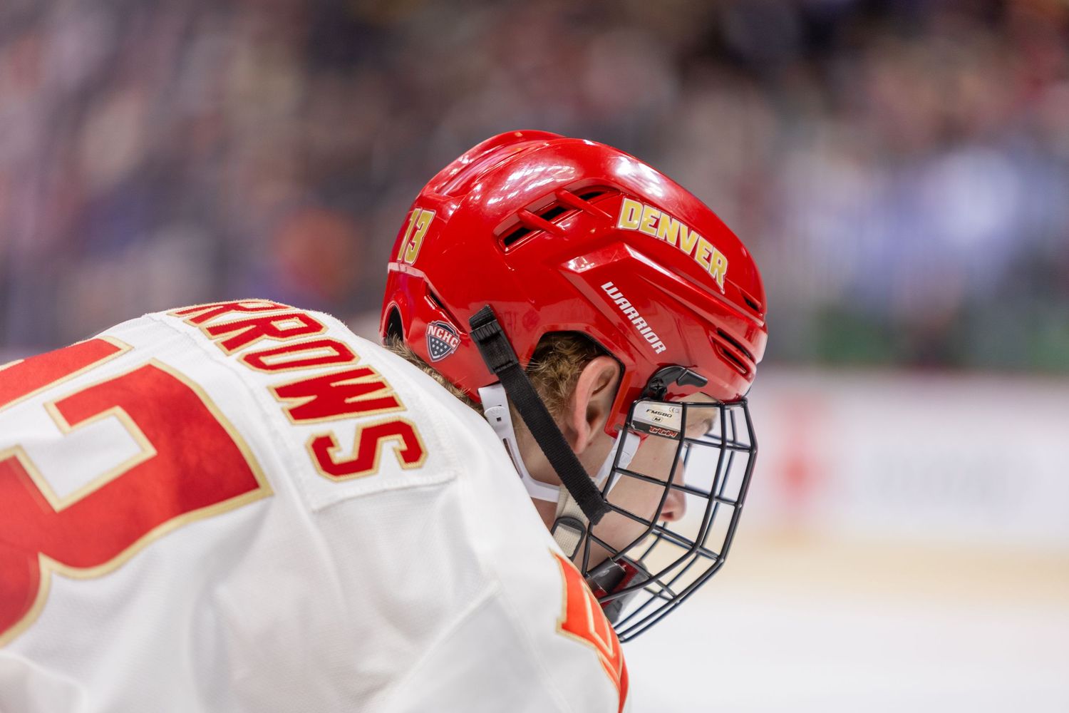 Hockey players in red jerseys collide during an intense match on the ice rink.