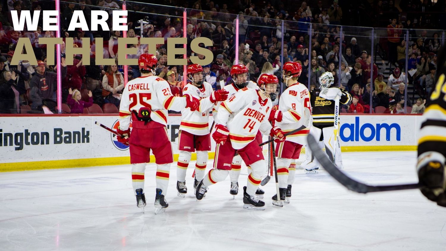 Calgary Flames players celebrate a goal on ice during an NHL game, wearing red and white jerseys.