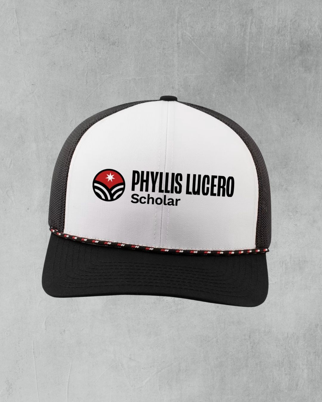White and black trucker hat with Phyllis Lucero Scholar logo, featuring red accents and mesh back panel.