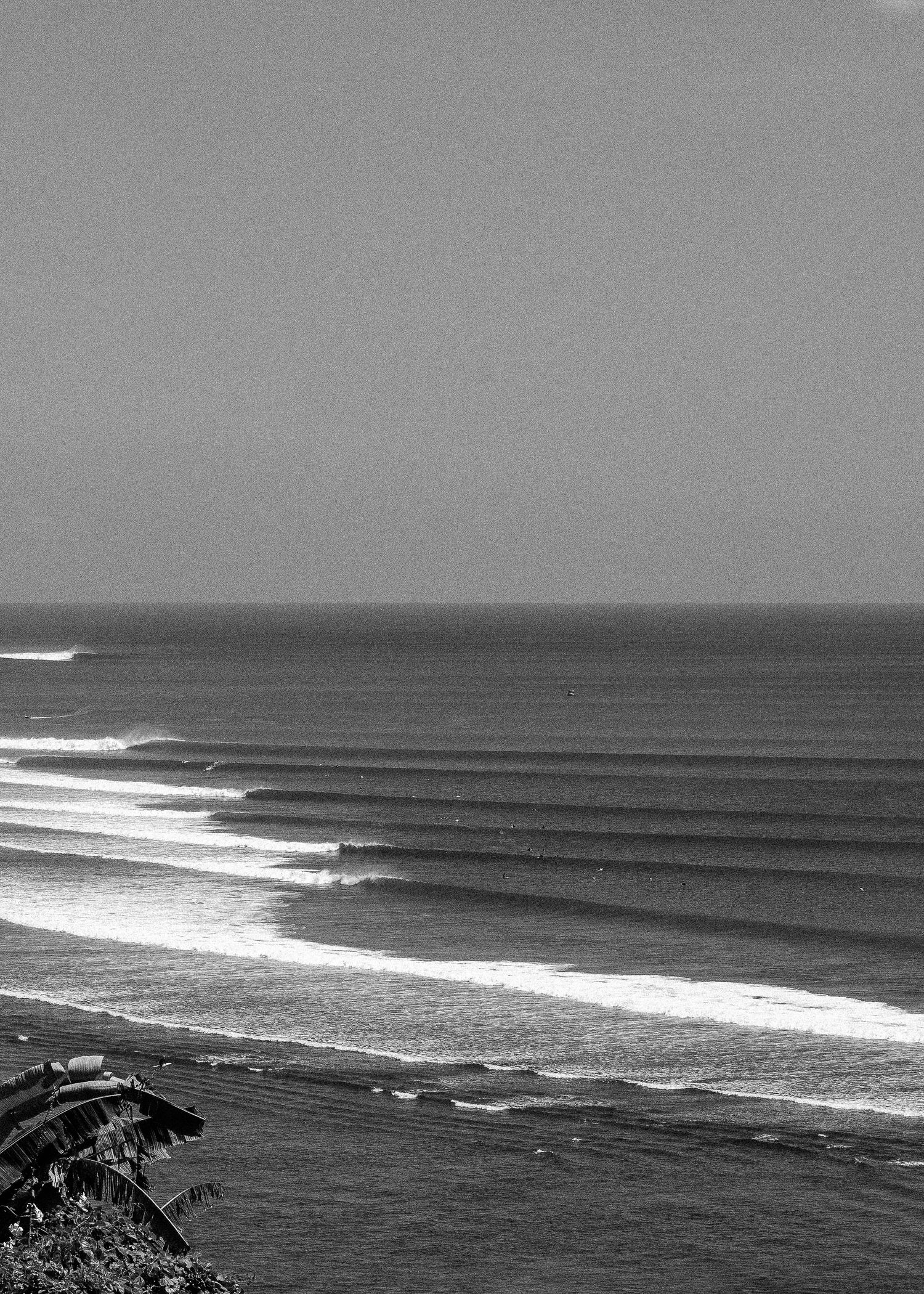 Black and white panoramic view of ocean waves breaking on a beach in Bali, Indonesia