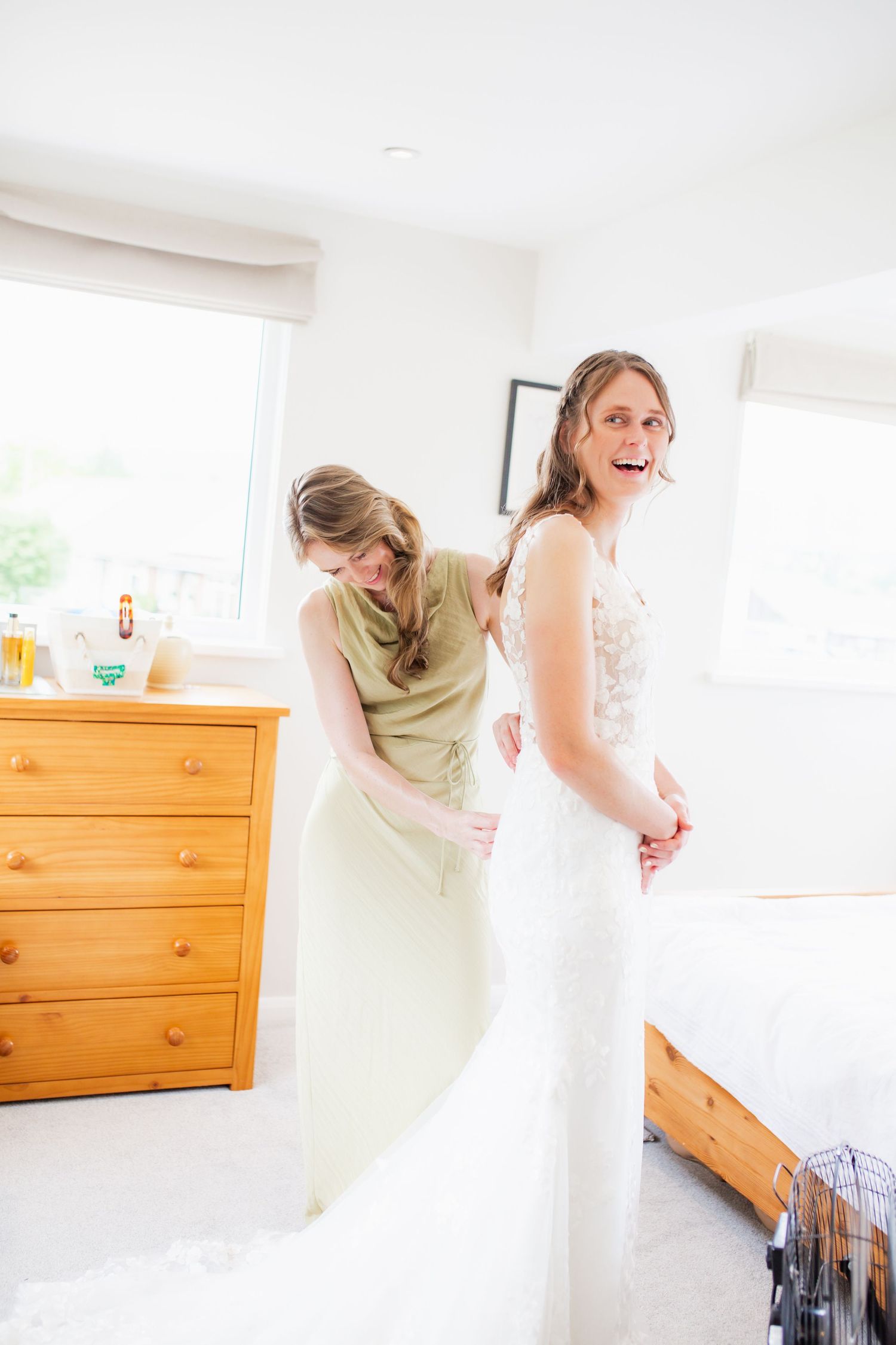 Wedding dress preparation sequence in bright white room.