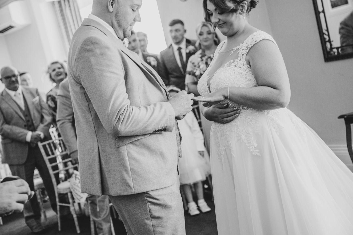Indoor wedding ceremony moments captured in black and white photography.