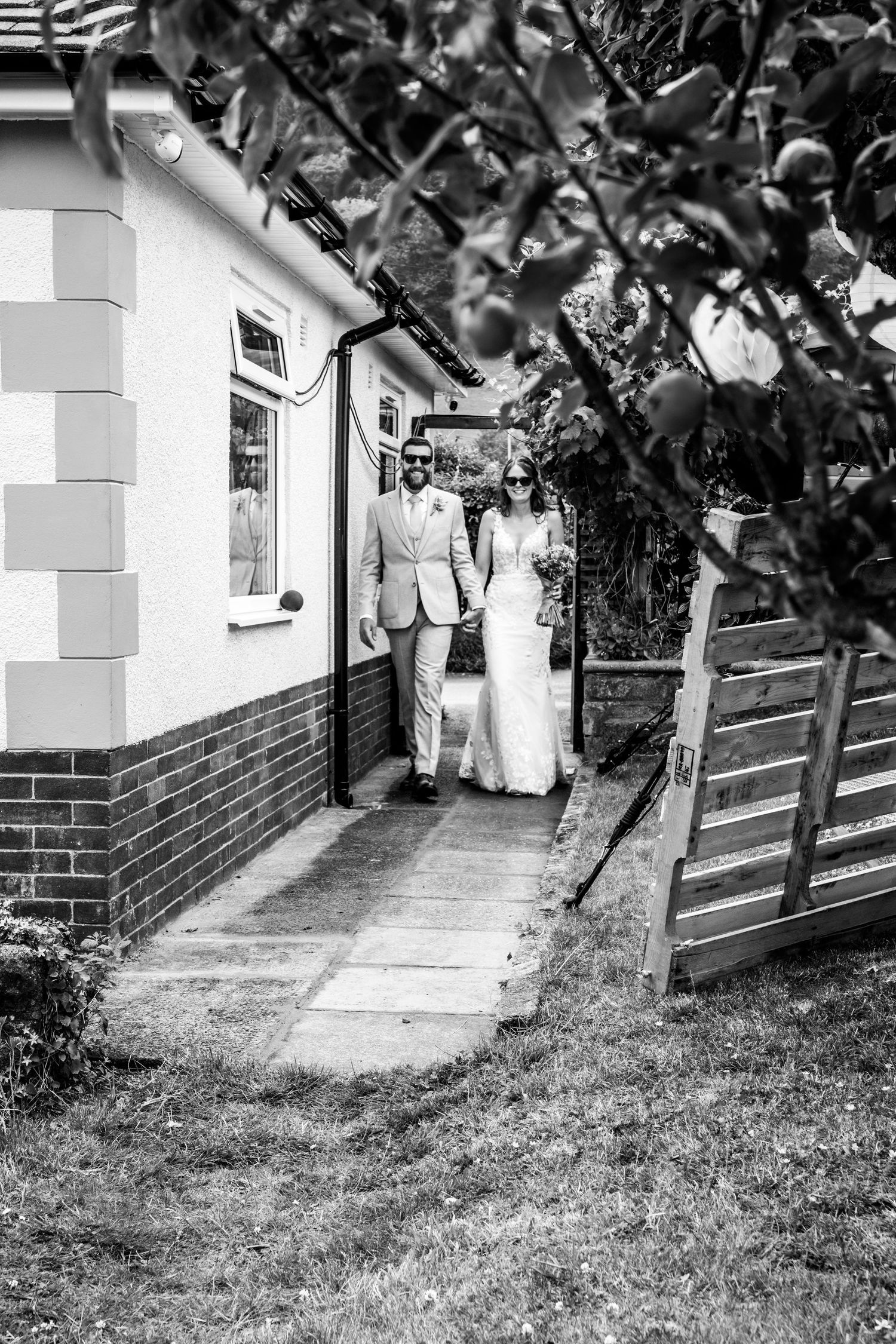 Black and white photo of a wedding couple entering their wedding party.