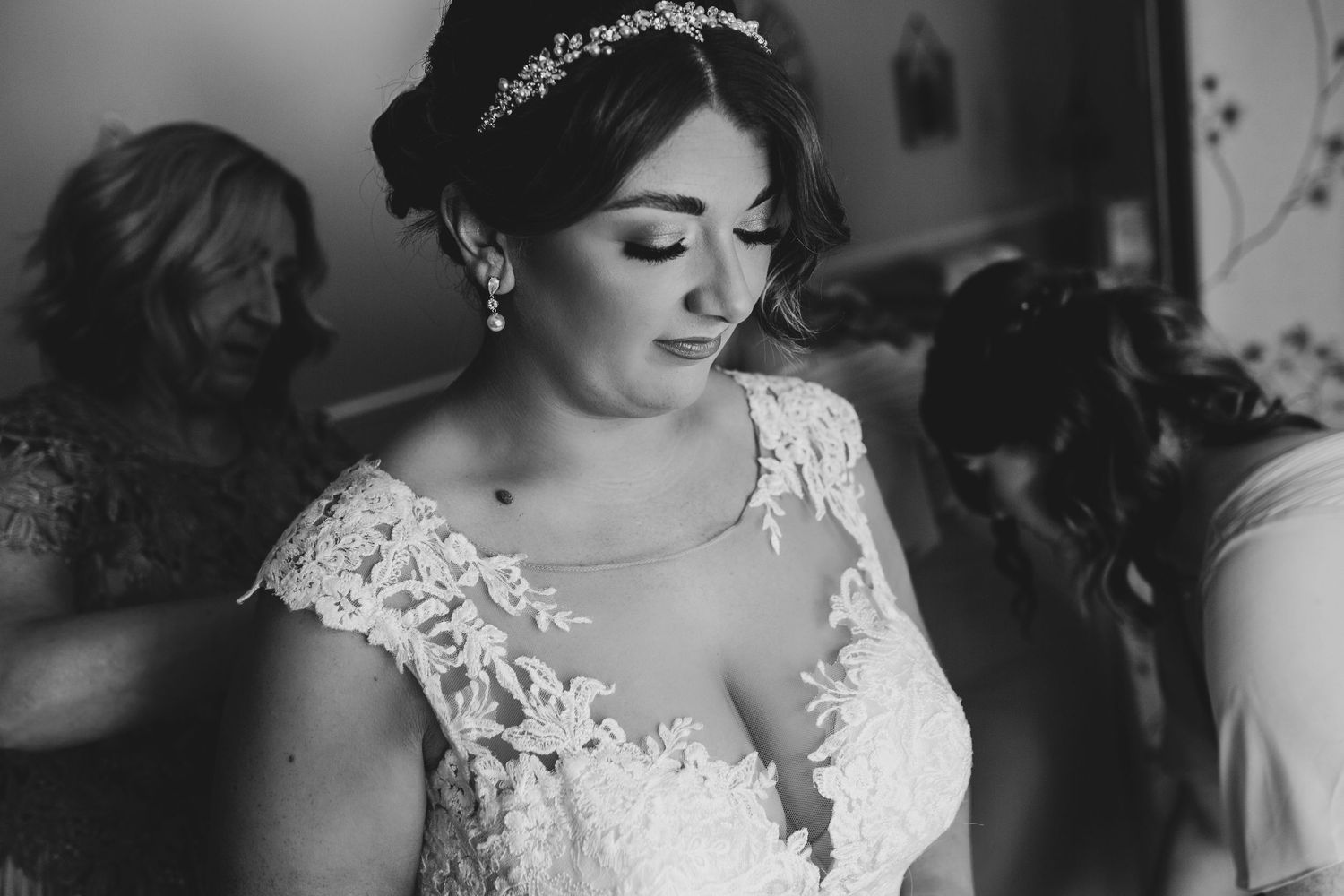 Black and white portrait showcasing intricate lace details of wedding dress.