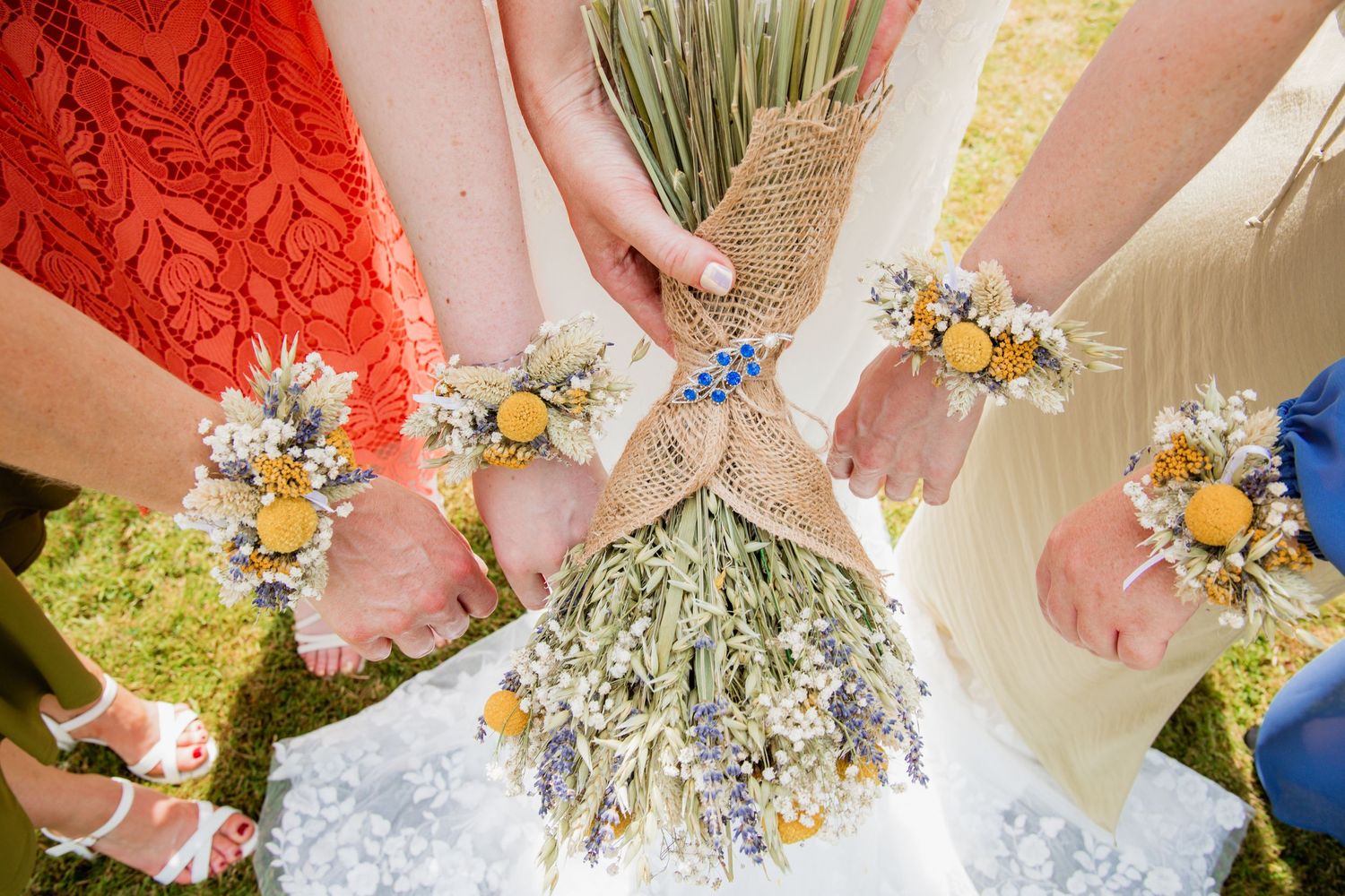 Close-up of bridesmaids holding delicate wildflower bouquets with dried elements.