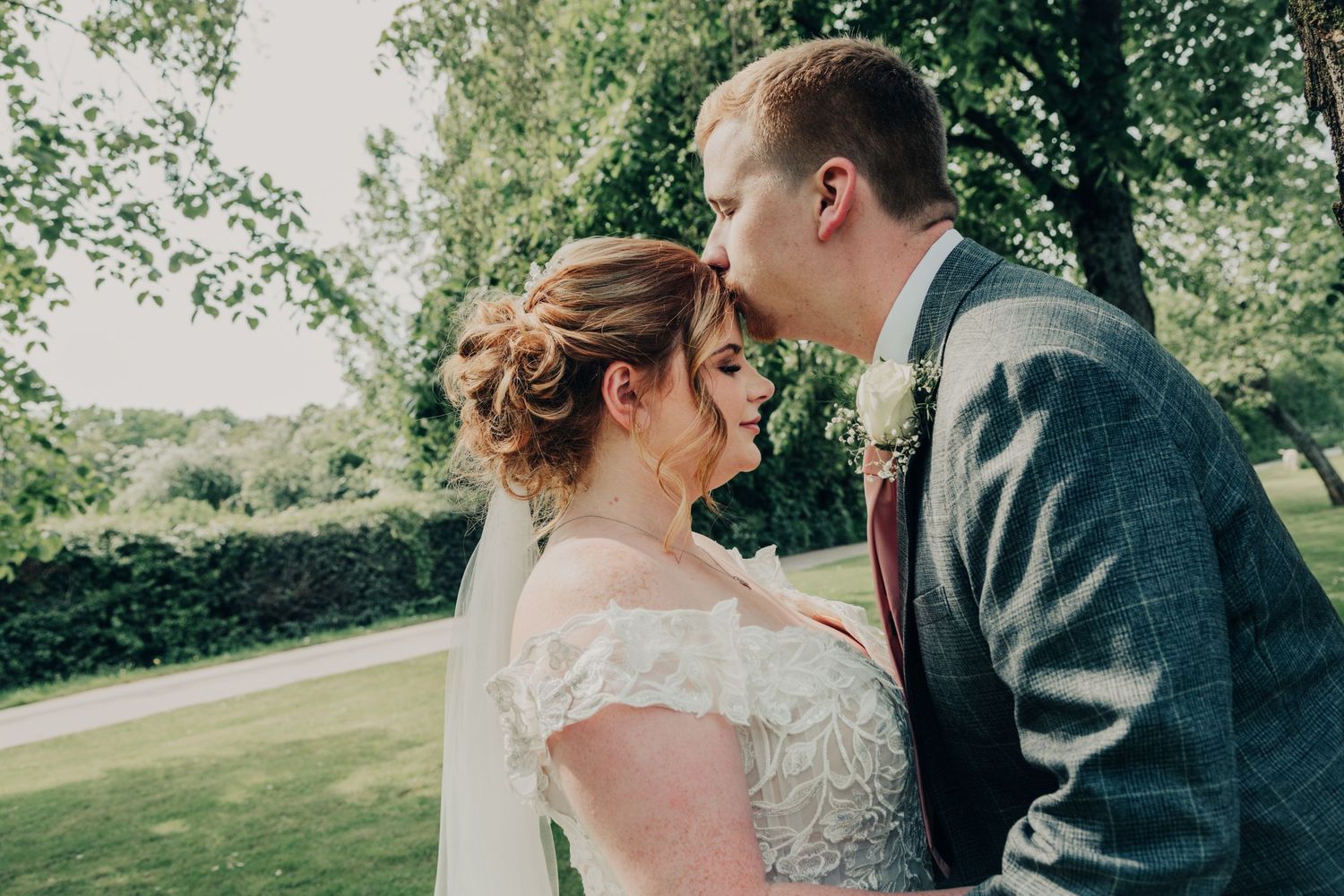 A romantic moment captured between newlyweds in an outdoor garden setting.