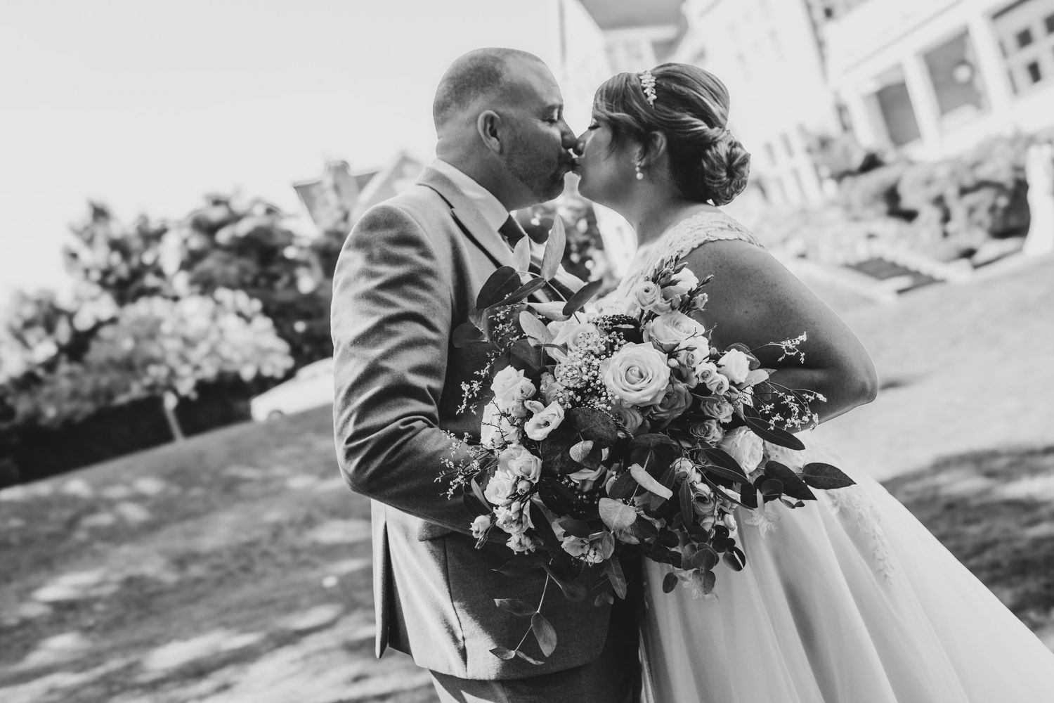 Wedding party posing with floral bouquets outdoors in natural light.