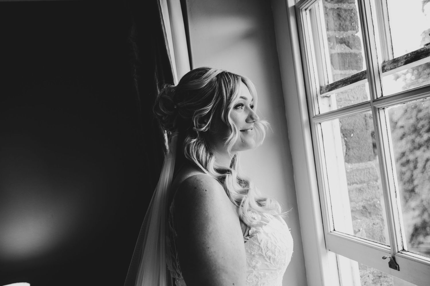 Elegant bridal portrait near window with soft natural lighting.