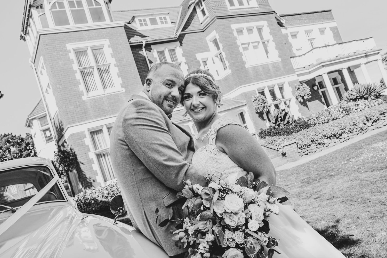 Wedding couple photographed in front of a classic white building exterior.