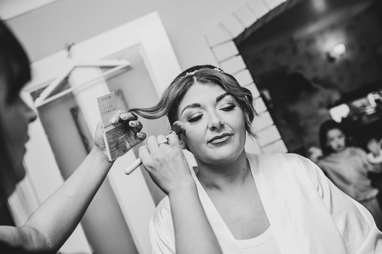Black and white image of wedding preparations with final touches being applied.