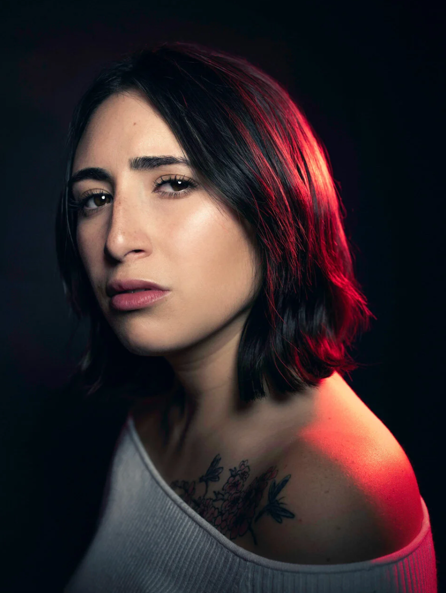 Dramatic portrait series with red lighting showing a figure with dark hair and neck tattoo in various poses against dark background.