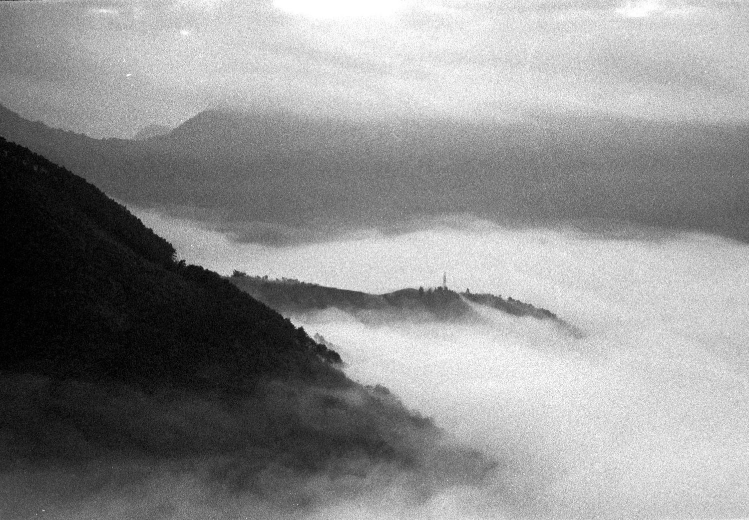 Black and white photograph of misty mountains with fog rolling through valleys.