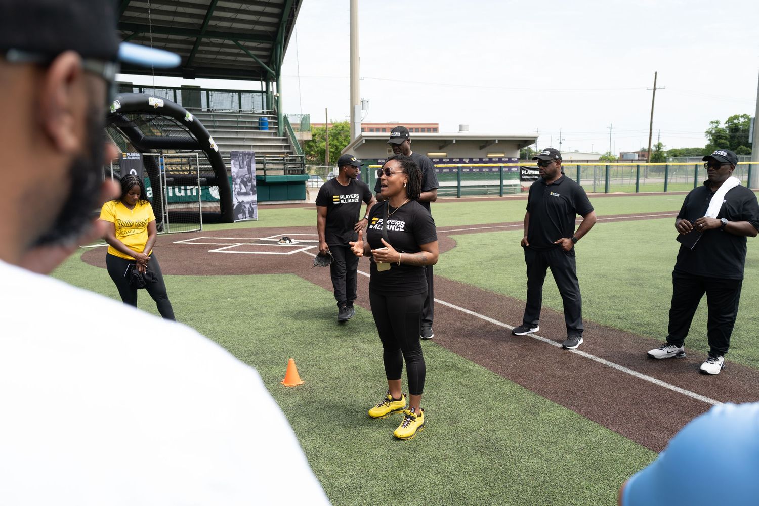 Training session on baseball field with instructors and participants practicing drills.