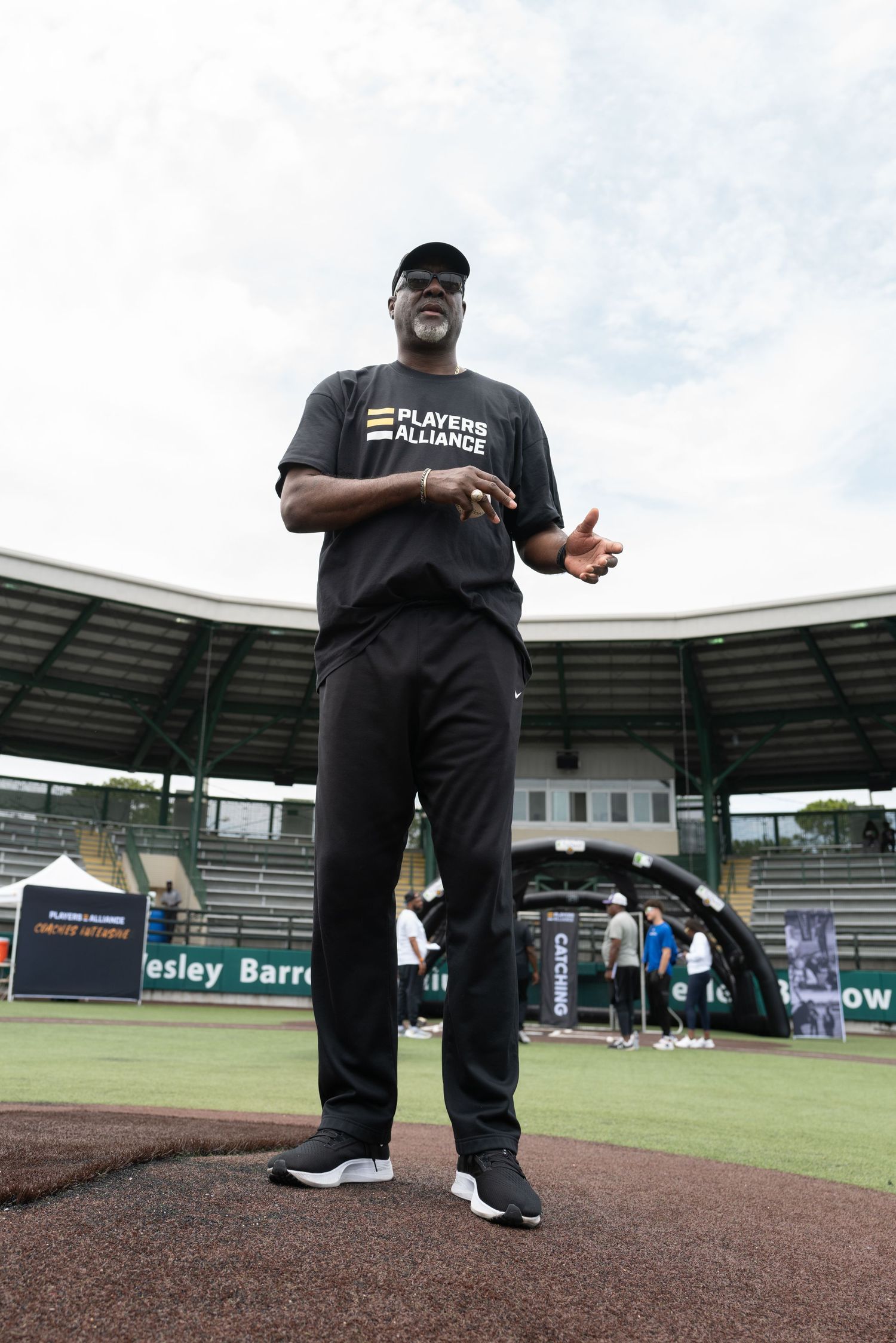 Instructor giving demonstration on baseball field with stadium seating in background.