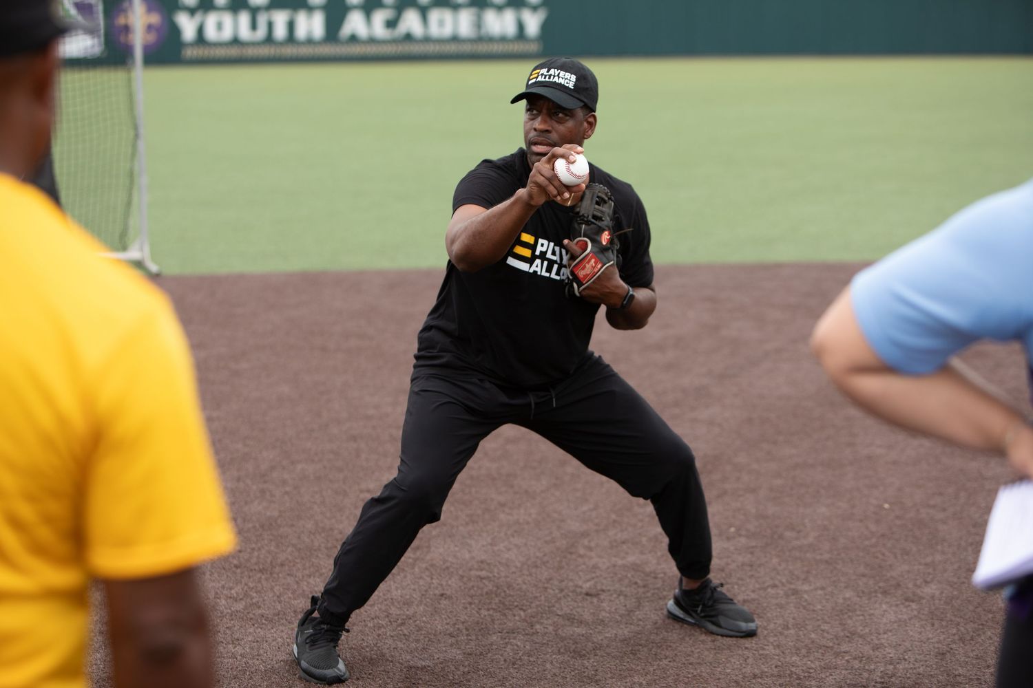 Baseball player demonstrating batting stance during training session on field.