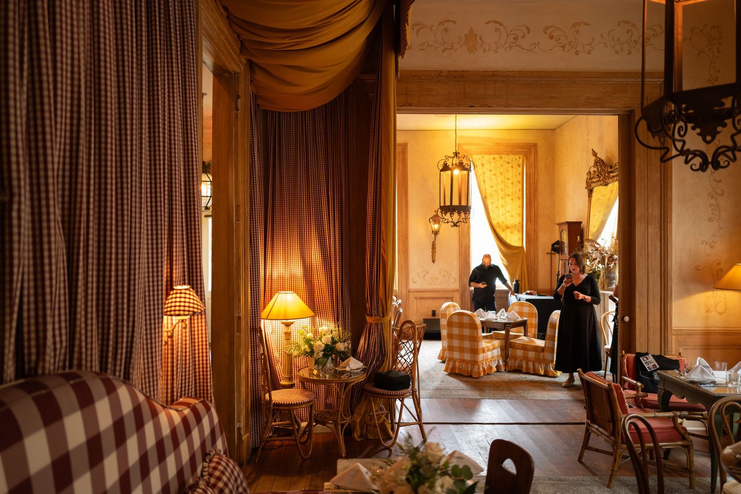 Elegant living room interior with warm lighting, classic furniture, and draped curtains creating a luxurious ambiance.