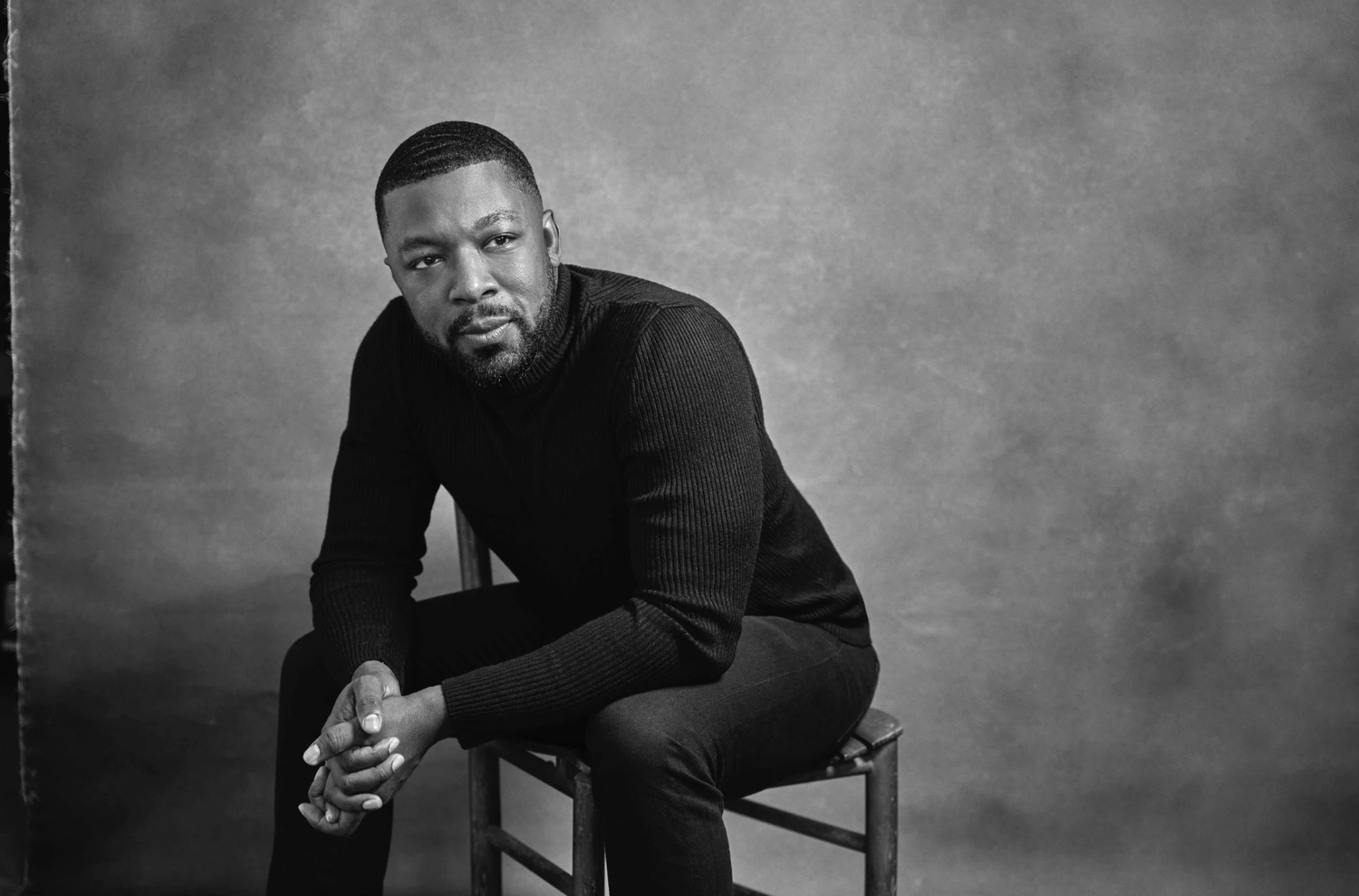 A series of black and white portraits showing a person in casual attire sitting on a chair against a gray background.