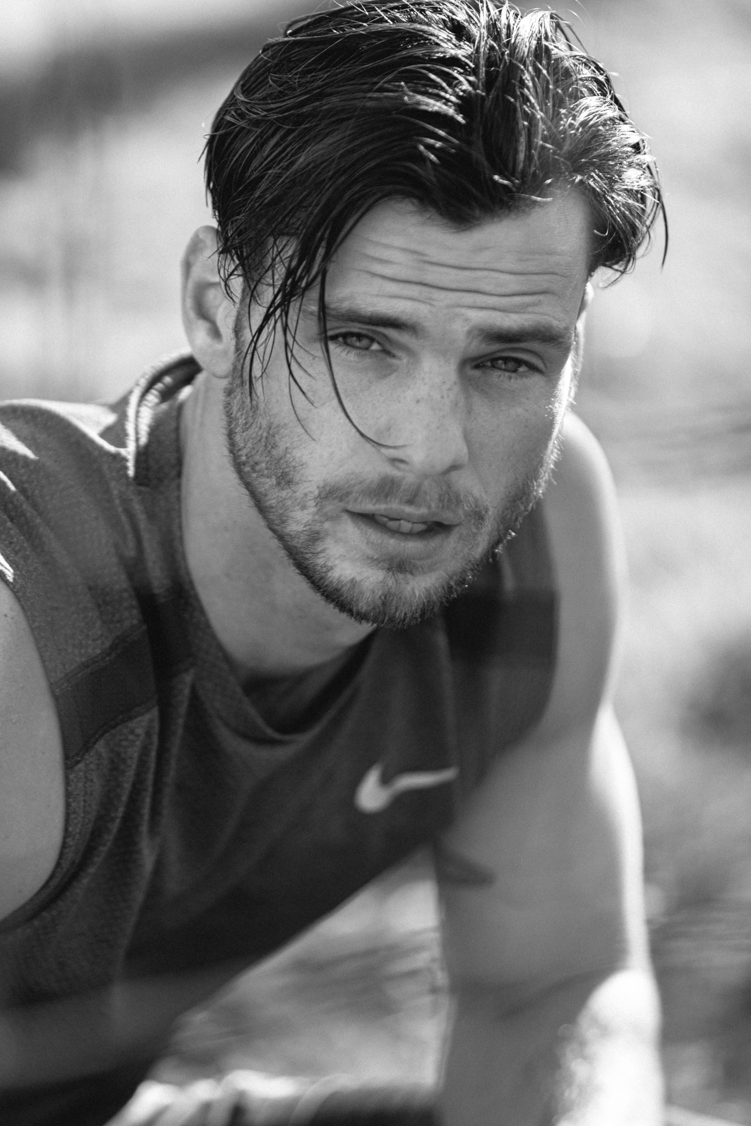 Close-up black and white portrait of an athletic person in a Nike shirt with wet hair.