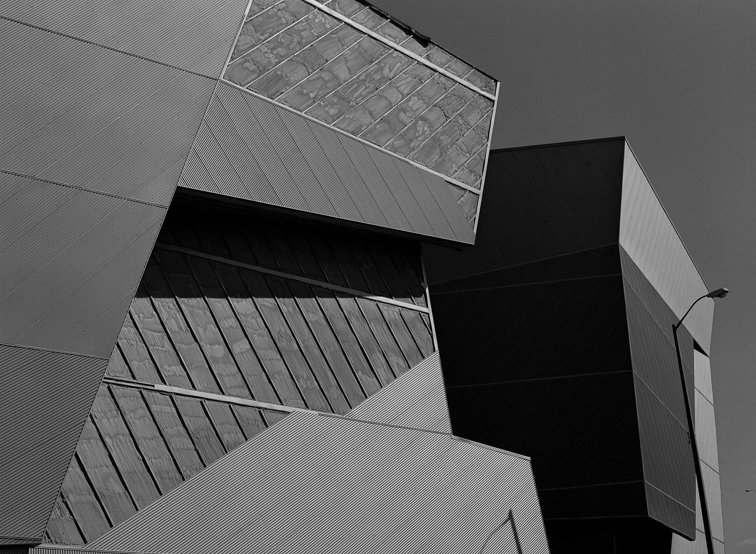 A series of black and white architectural photographs showing geometric patterns and shadows on building surfaces.