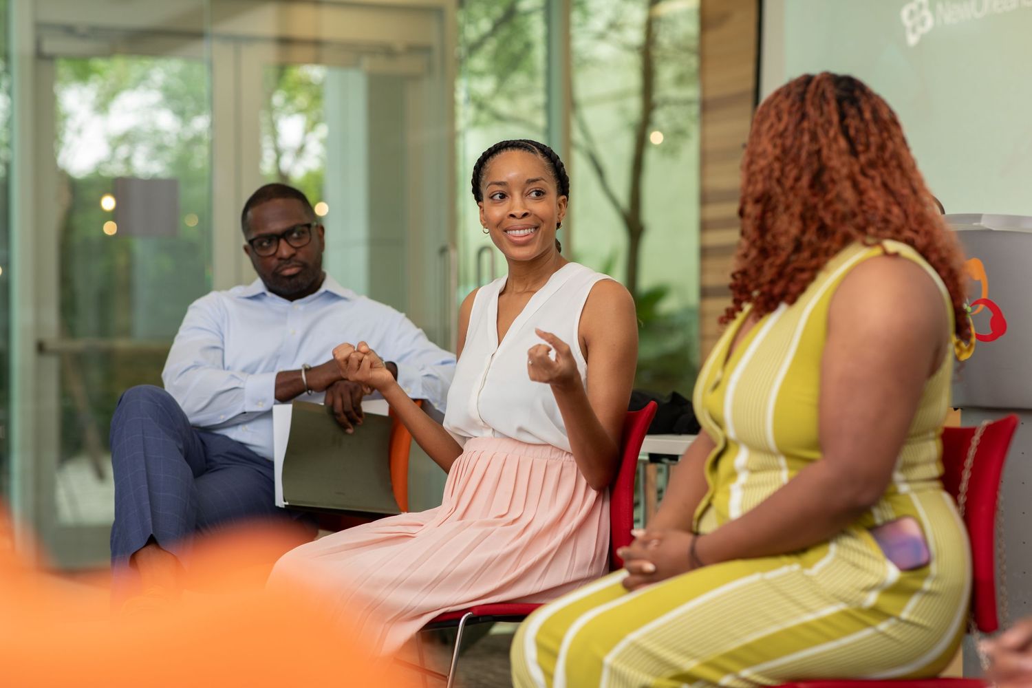 Colleagues having a collaborative meeting in a bright office space with colorful chairs.