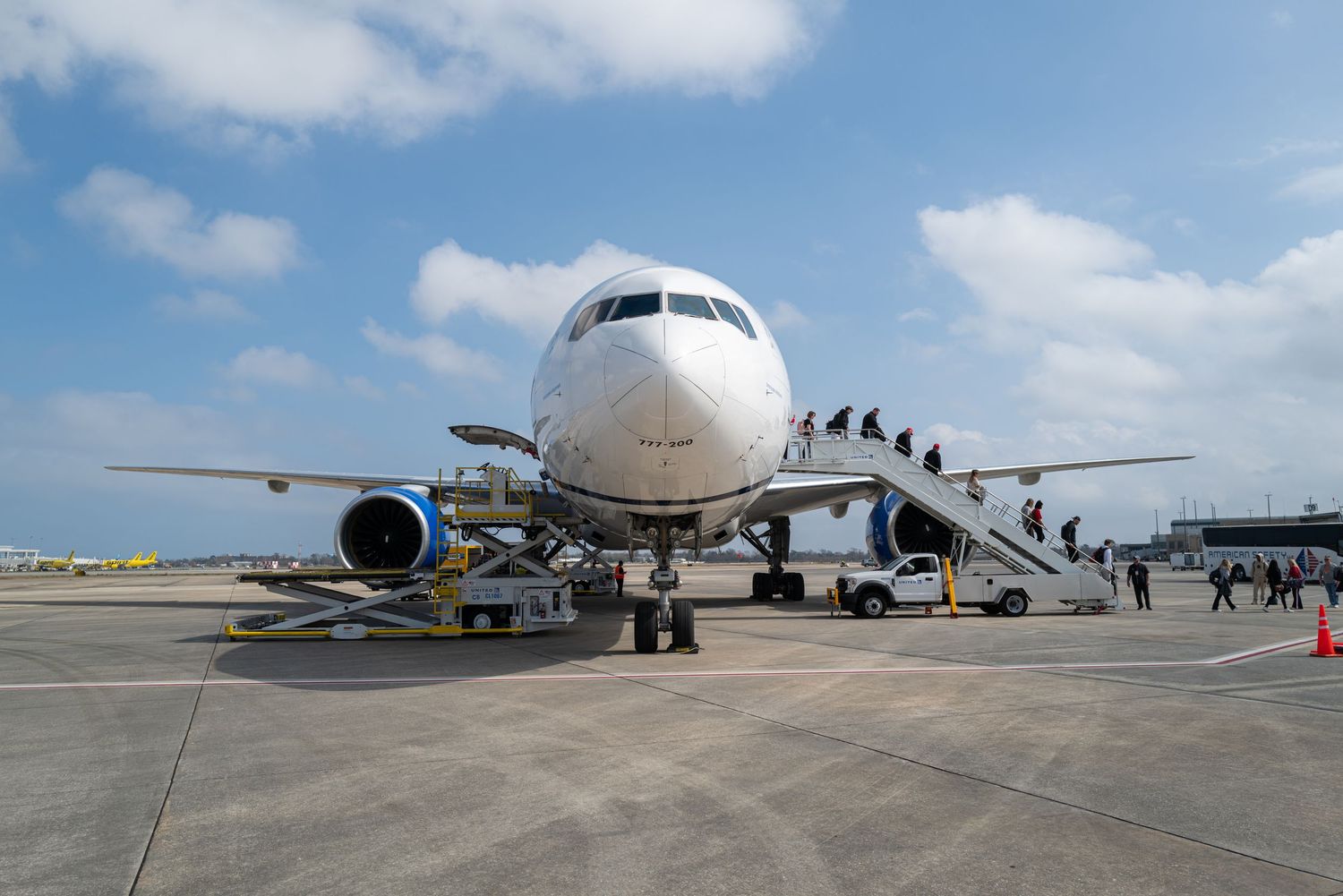 Front view of commercial aircraft with passenger boarding stairs attached.