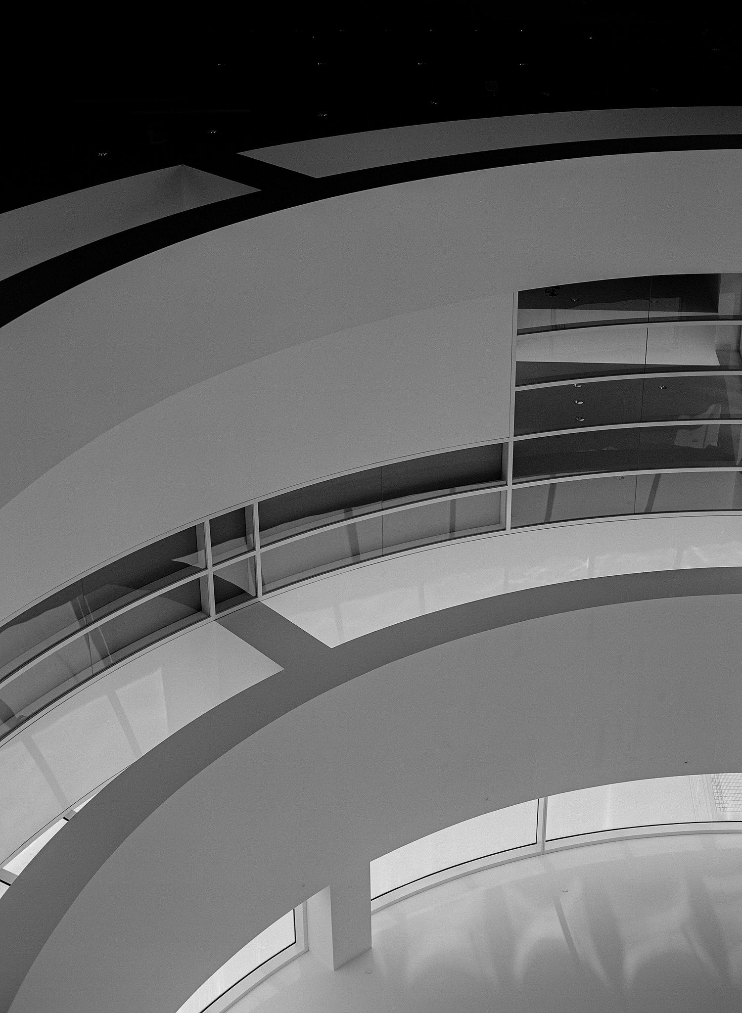 Black and white architectural photograph of curved modern building balconies with minimalist design.