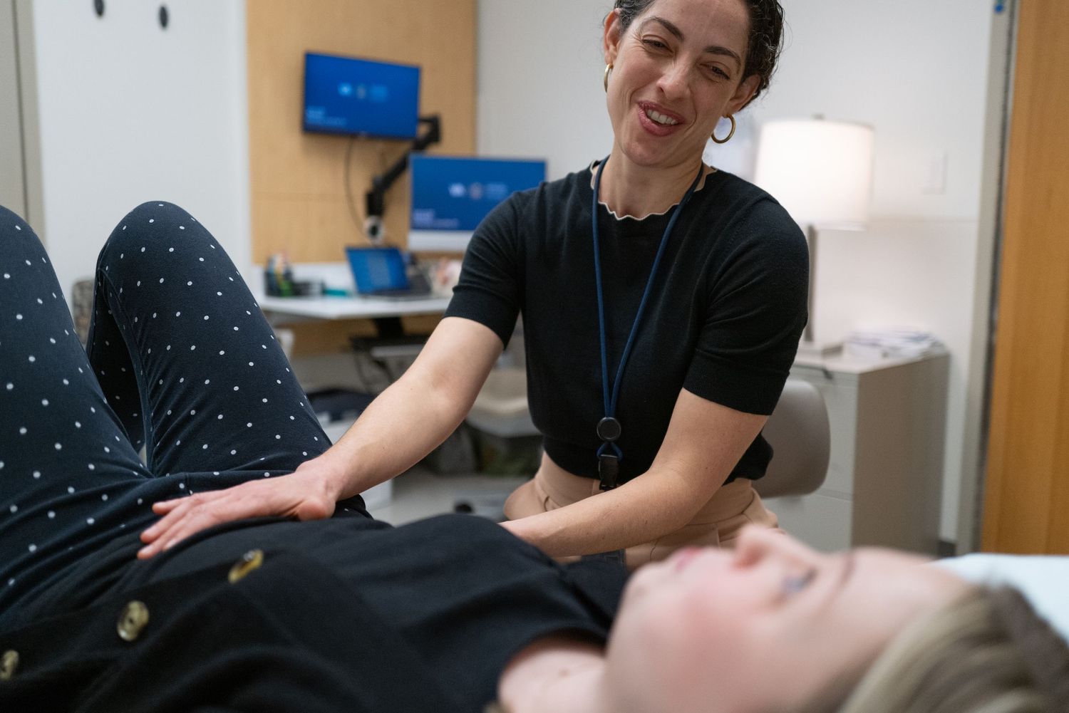 Healthcare professional performing medical examination in clinical setting.