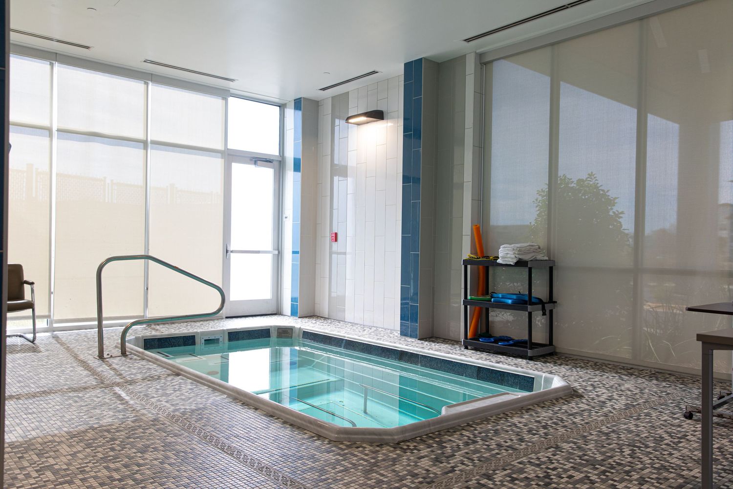 Indoor therapy pool with glass windows and modern interior design features.