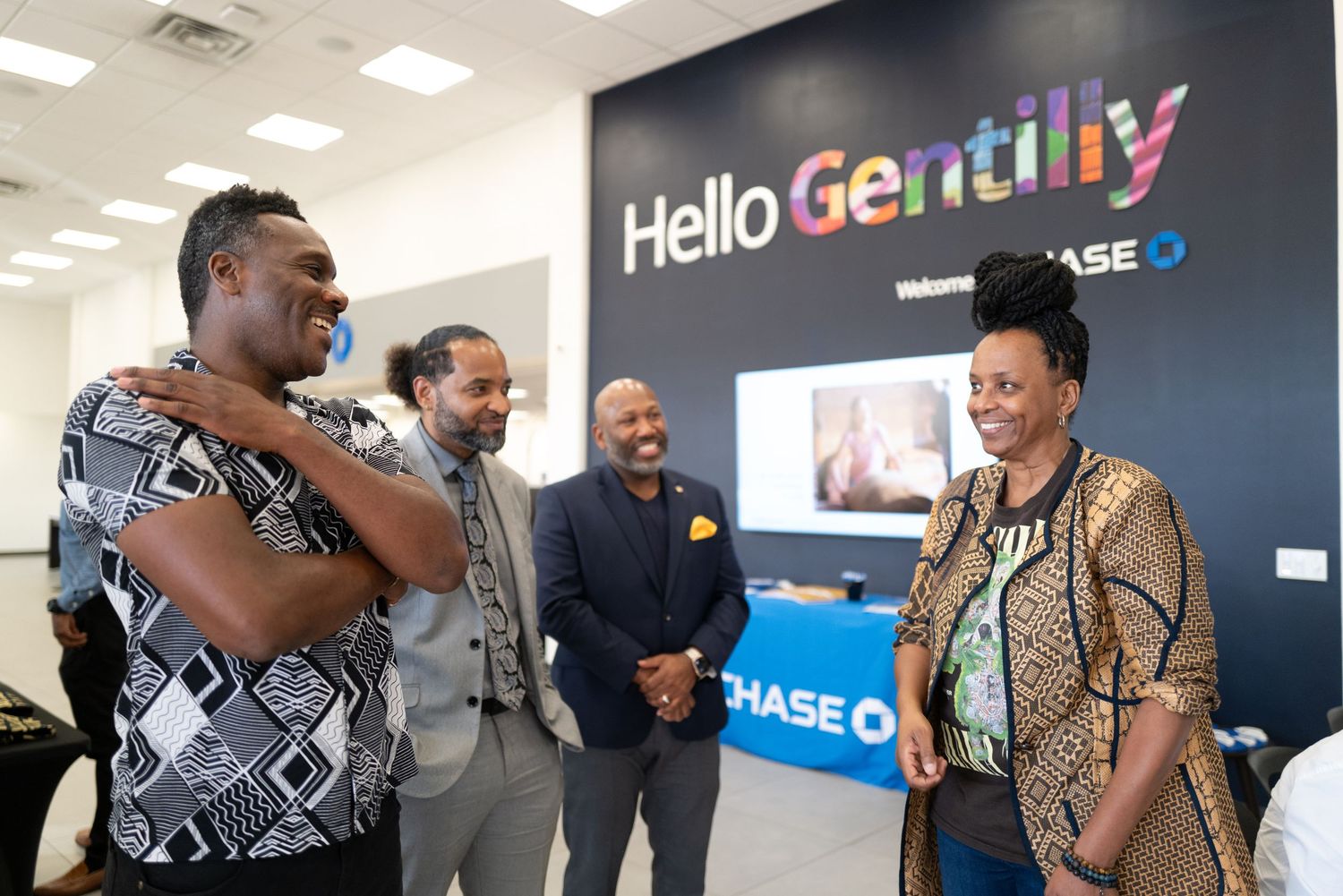 Professionals having an animated discussion in front of a Hello Gently wall display.