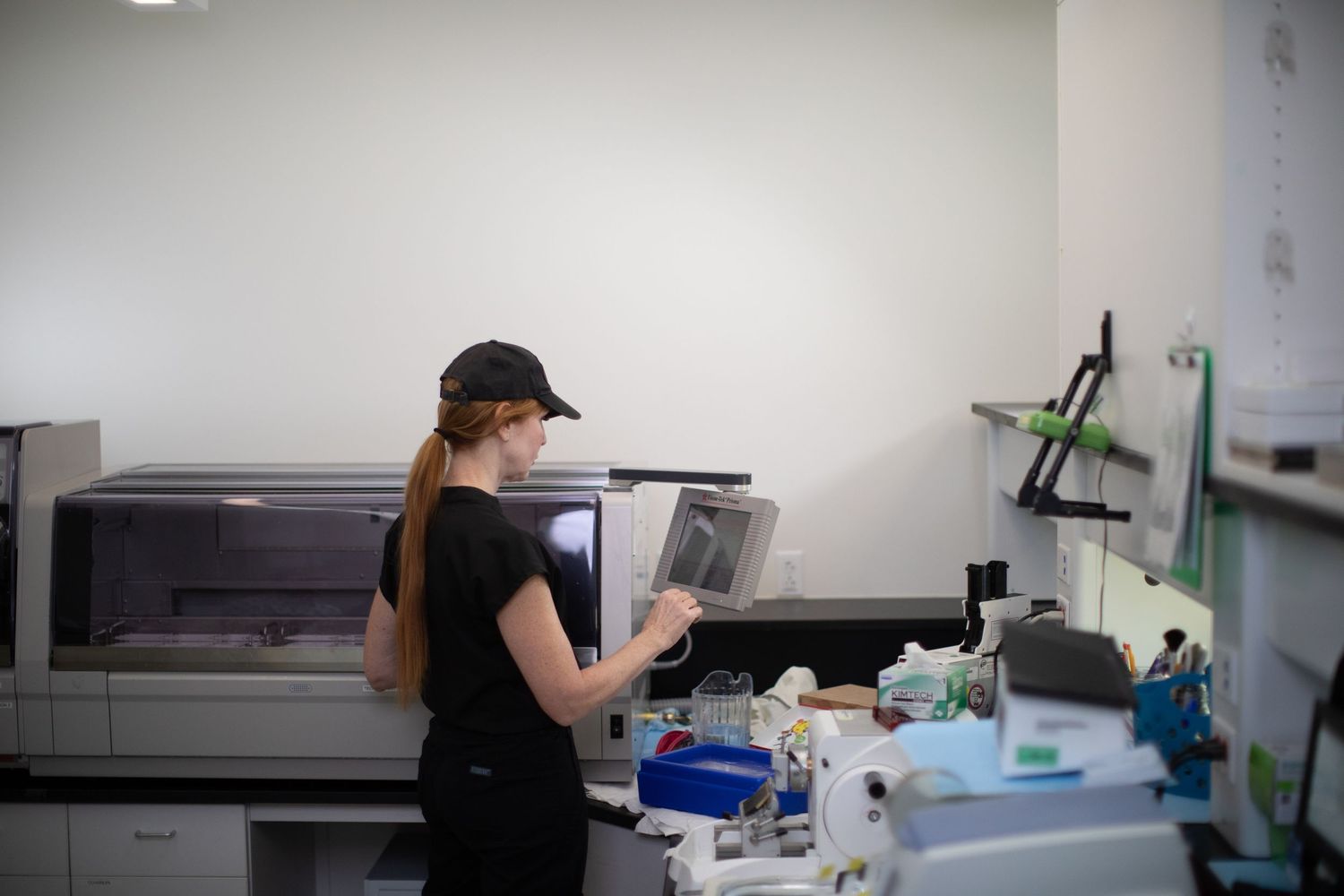 Laboratory technician analyzing samples at medical testing workstation.