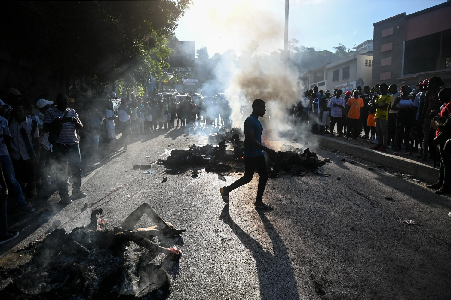 Protesters clash with police amid tear gas and smoke during street demonstrations in an urban setting.