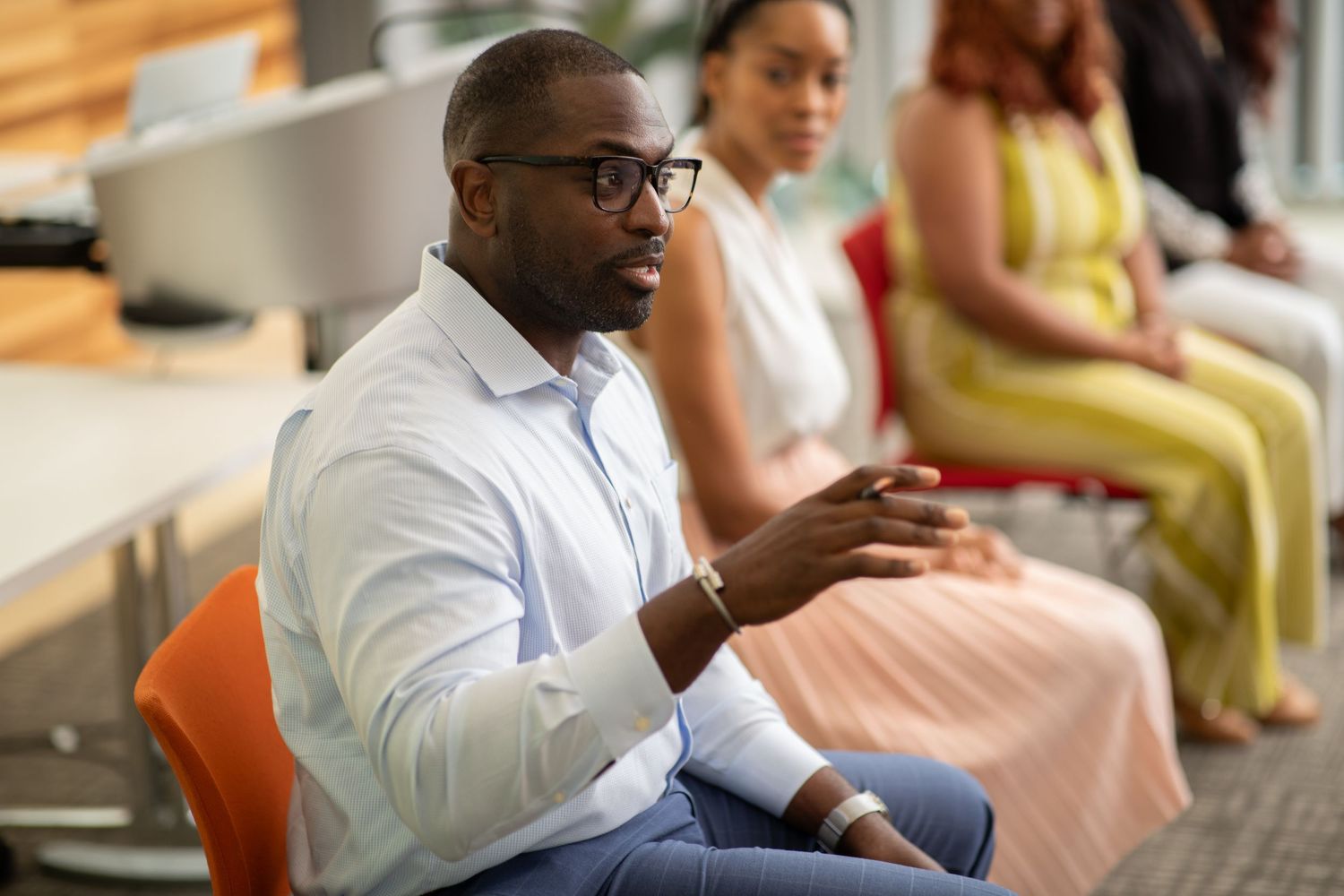 People sitting in modern office chairs during a professional meeting or discussion.