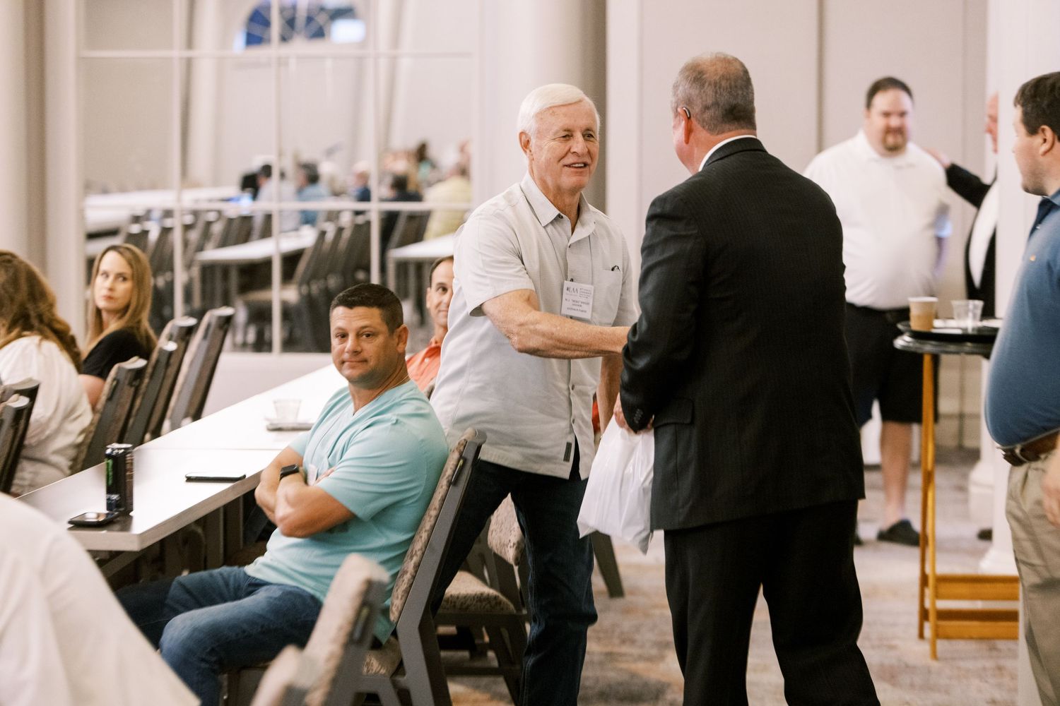 Attendees interact during a break at a professional conference or meeting.