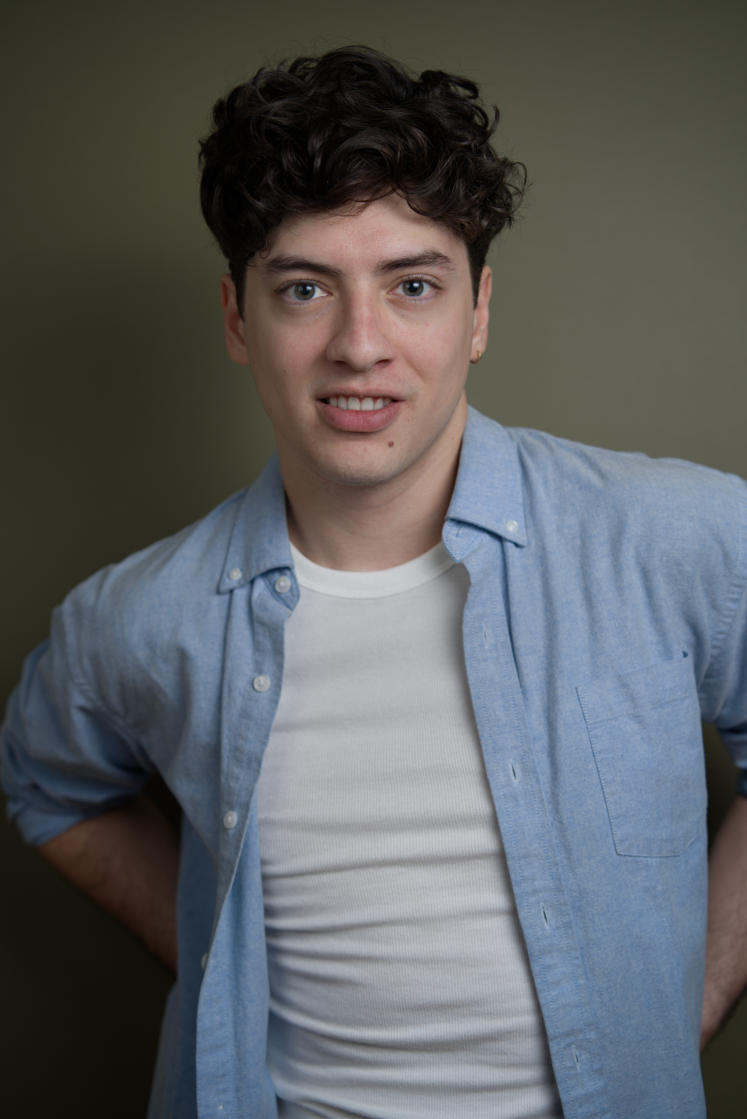 A series of five similar photos showing someone wearing a light blue button-down shirt over a white t-shirt.