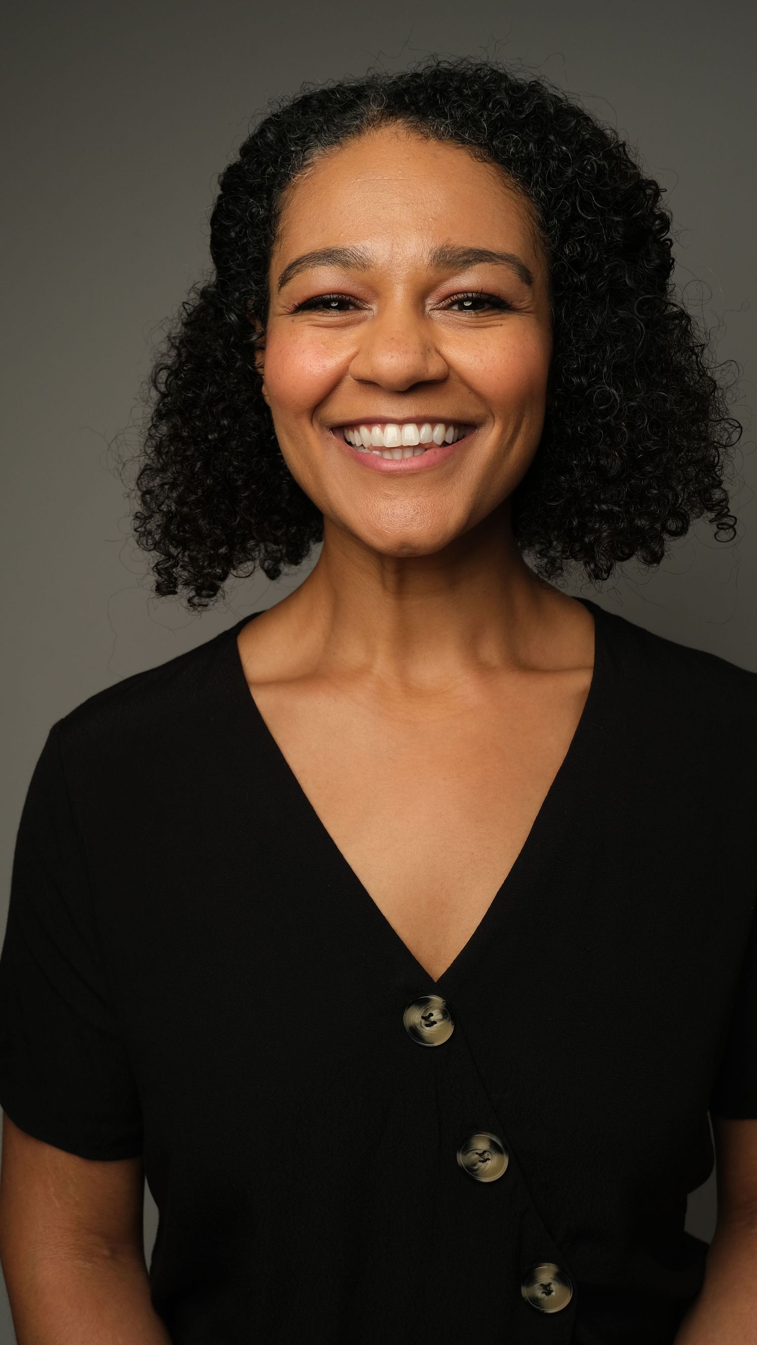 A series of five professional headshots showing a person with curly hair wearing a black top against a neutral background.