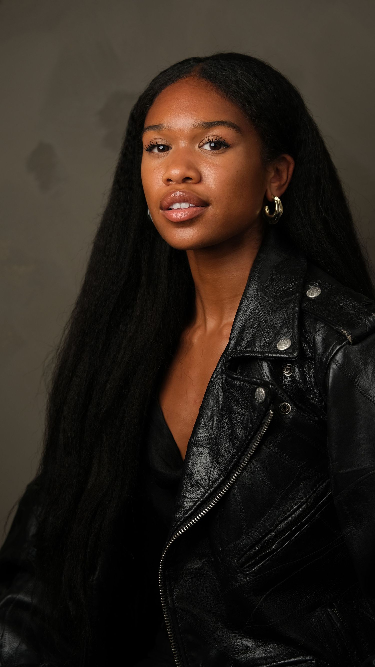 Professional portrait series of a model wearing a black leather jacket against a dark background with dramatic lighting.