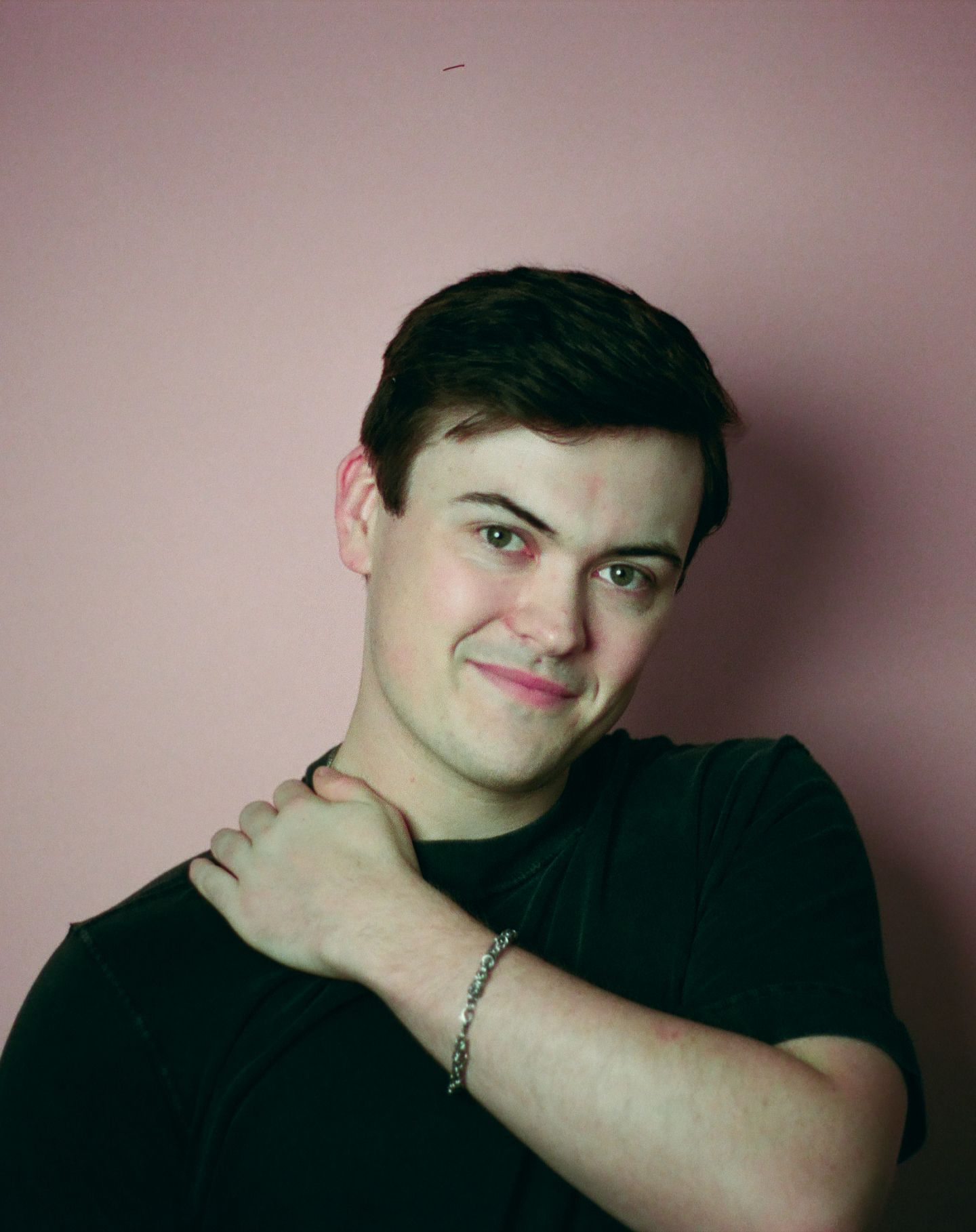 A series of artistic headshots in a split photo arrangement with dark lighting against a reddish background.