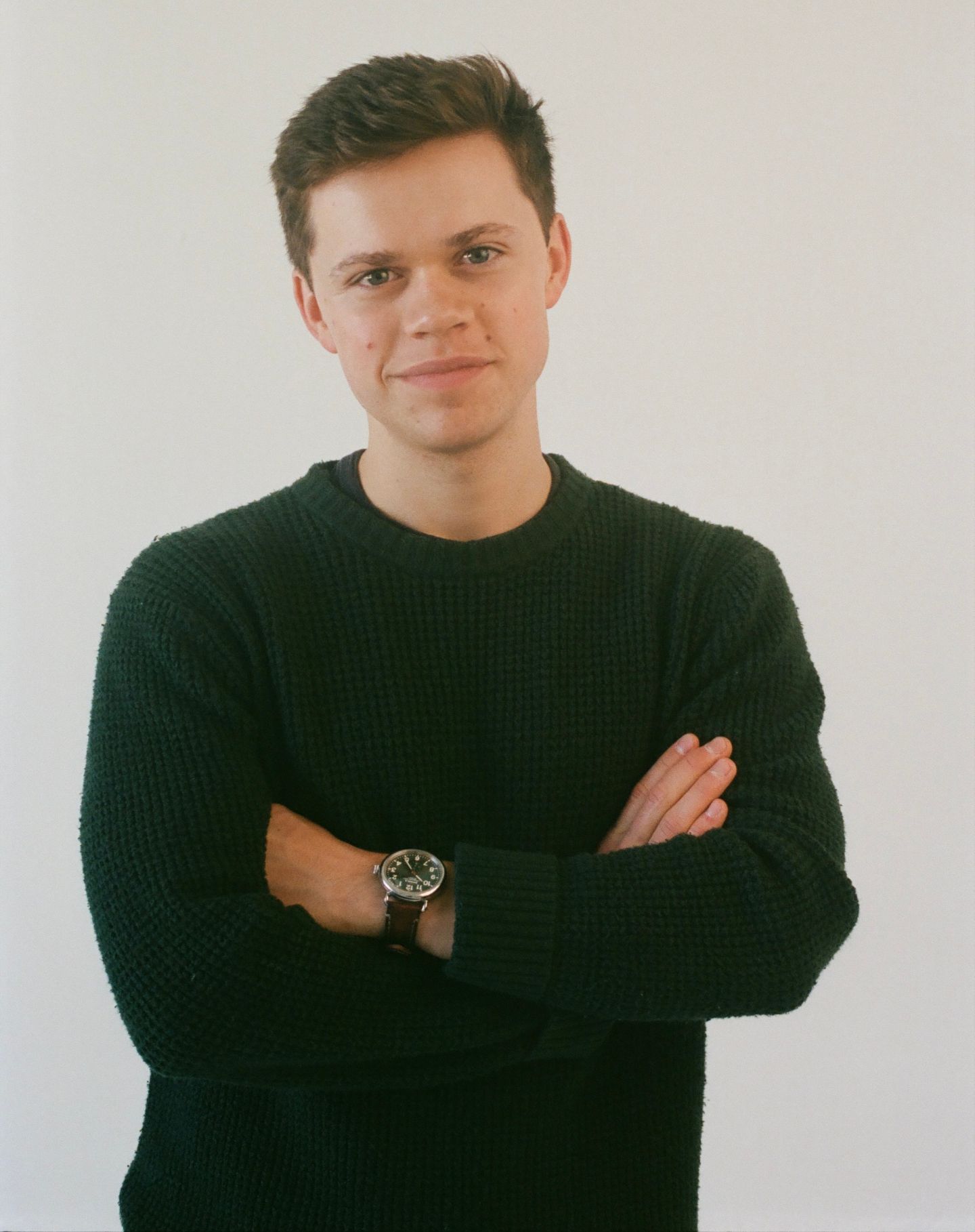 Four similar shots of a person in a black sweater posing against a white background with different expressive gestures.