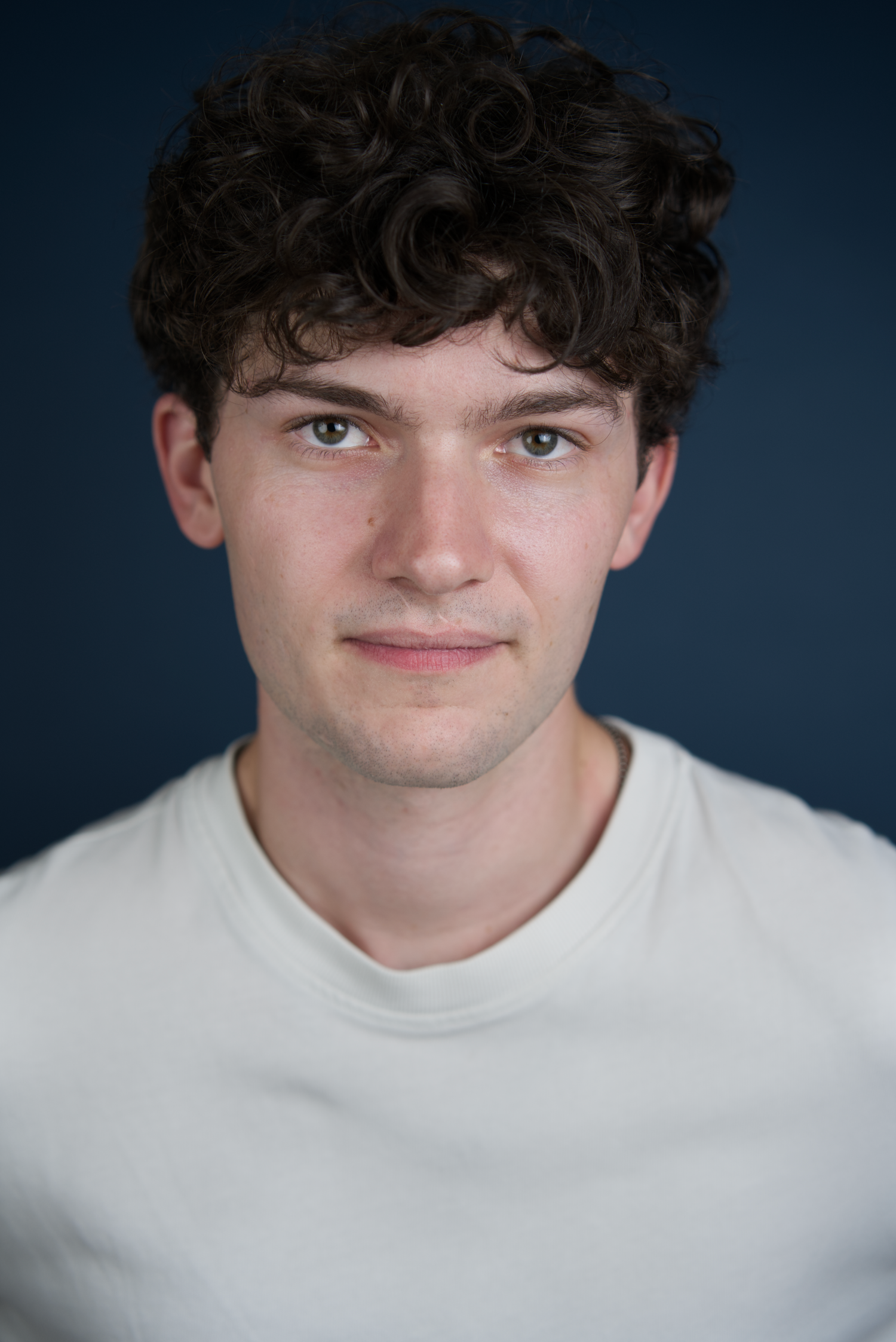 A person wearing a white sweater is shown in a series of headshots against a dark background.
