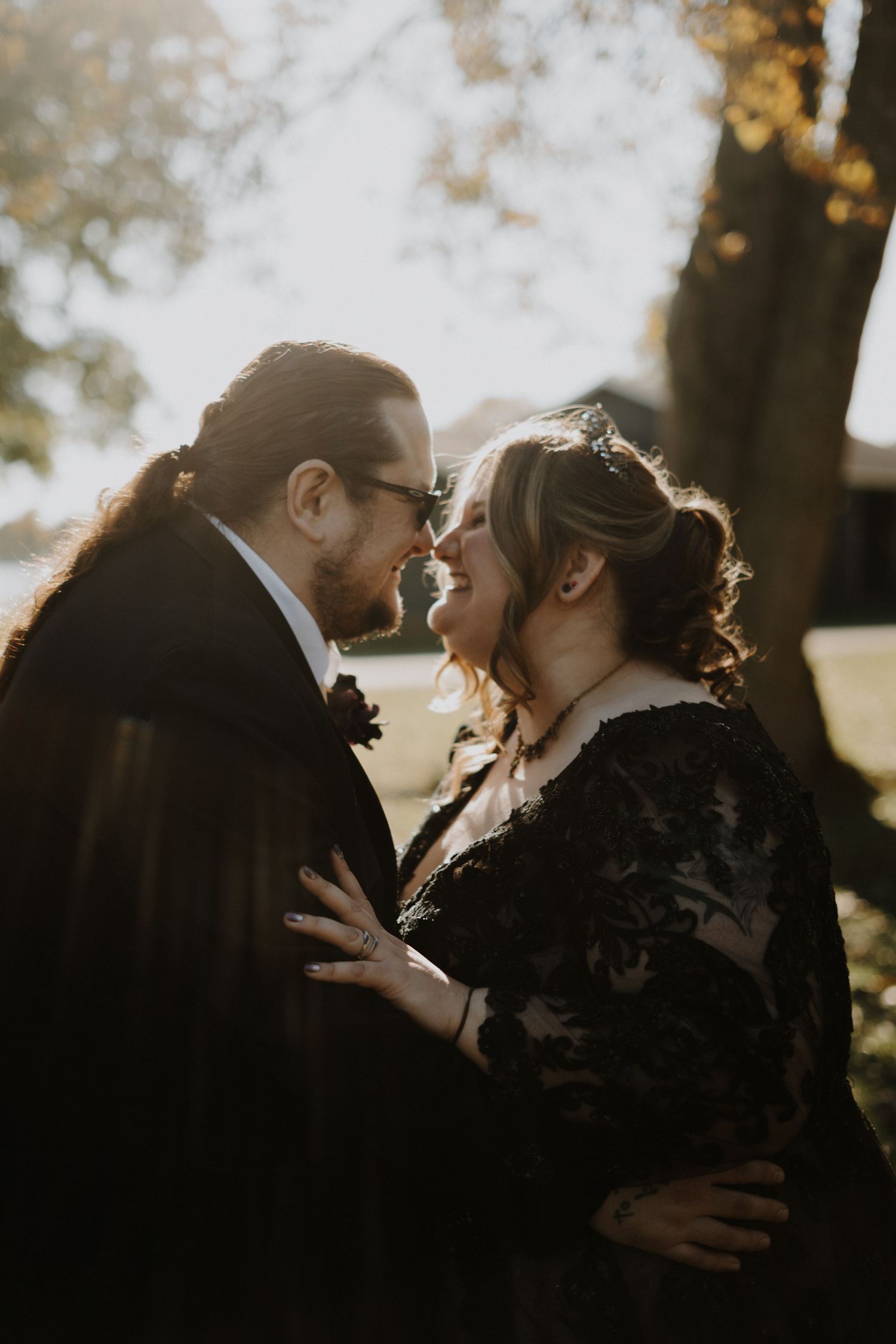 Intimate sunset portrait of newlyweds sharing a romantic moment in golden light.