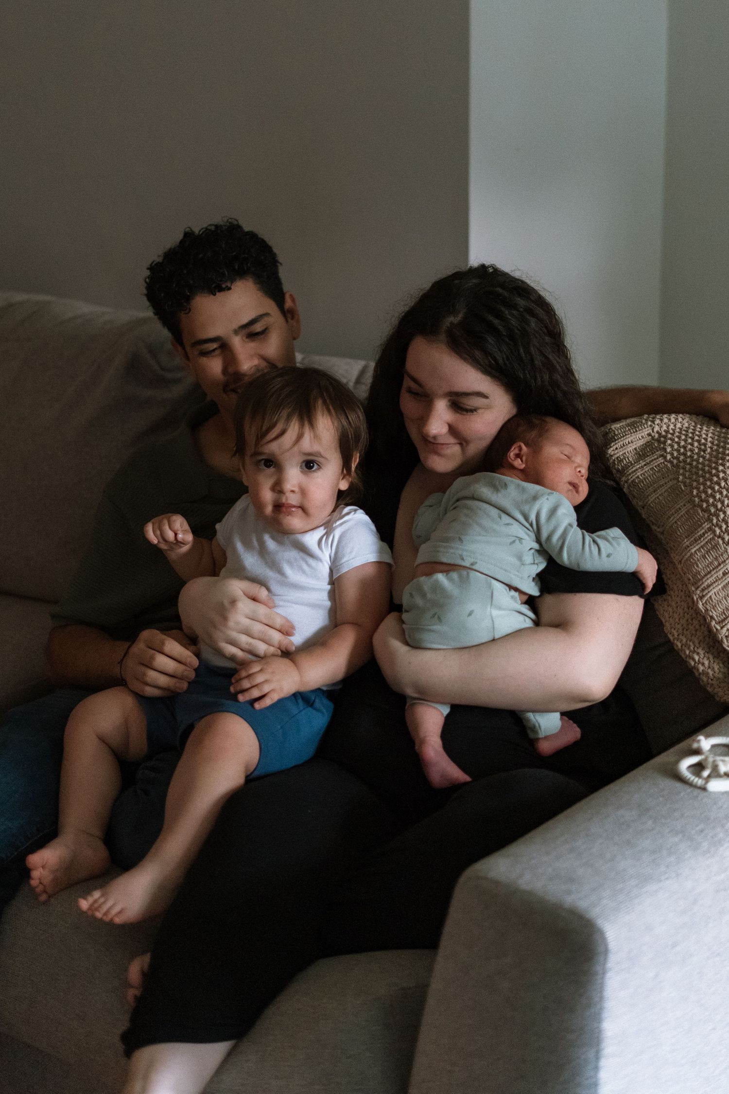 Intimate family moments captured in a series of dimly lit photos showing tender embraces and cuddles.