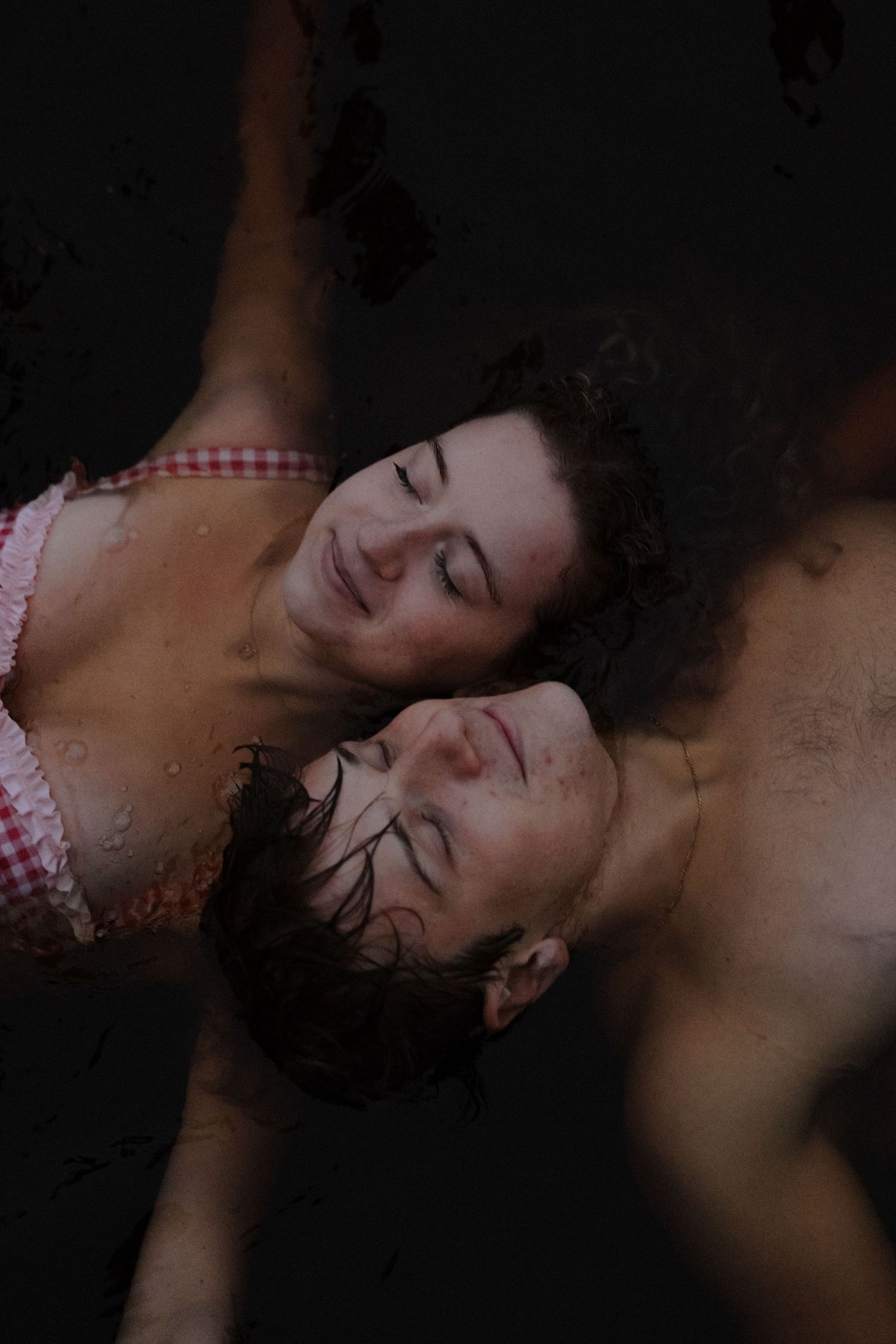 A sequence of dark moody portraits showing a reclining figure against a black background.