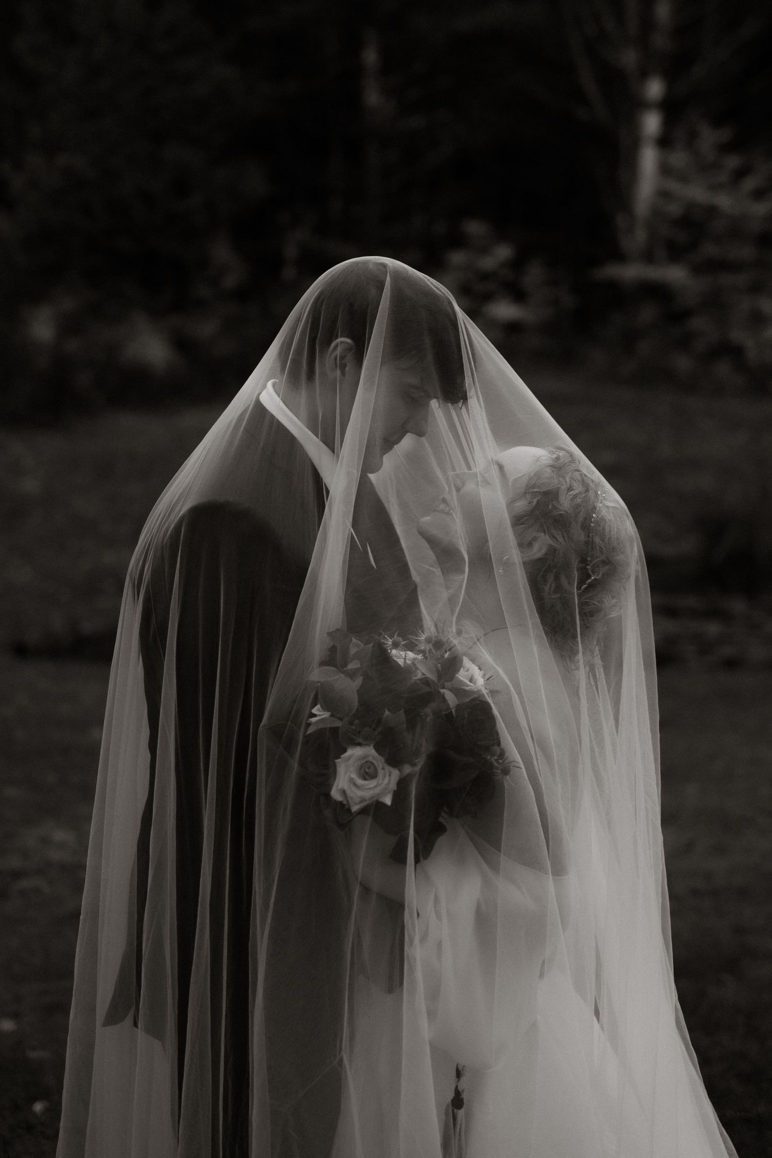 A black and white artistic photo series showing a flowing bridal veil blowing in the wind against a dark background.