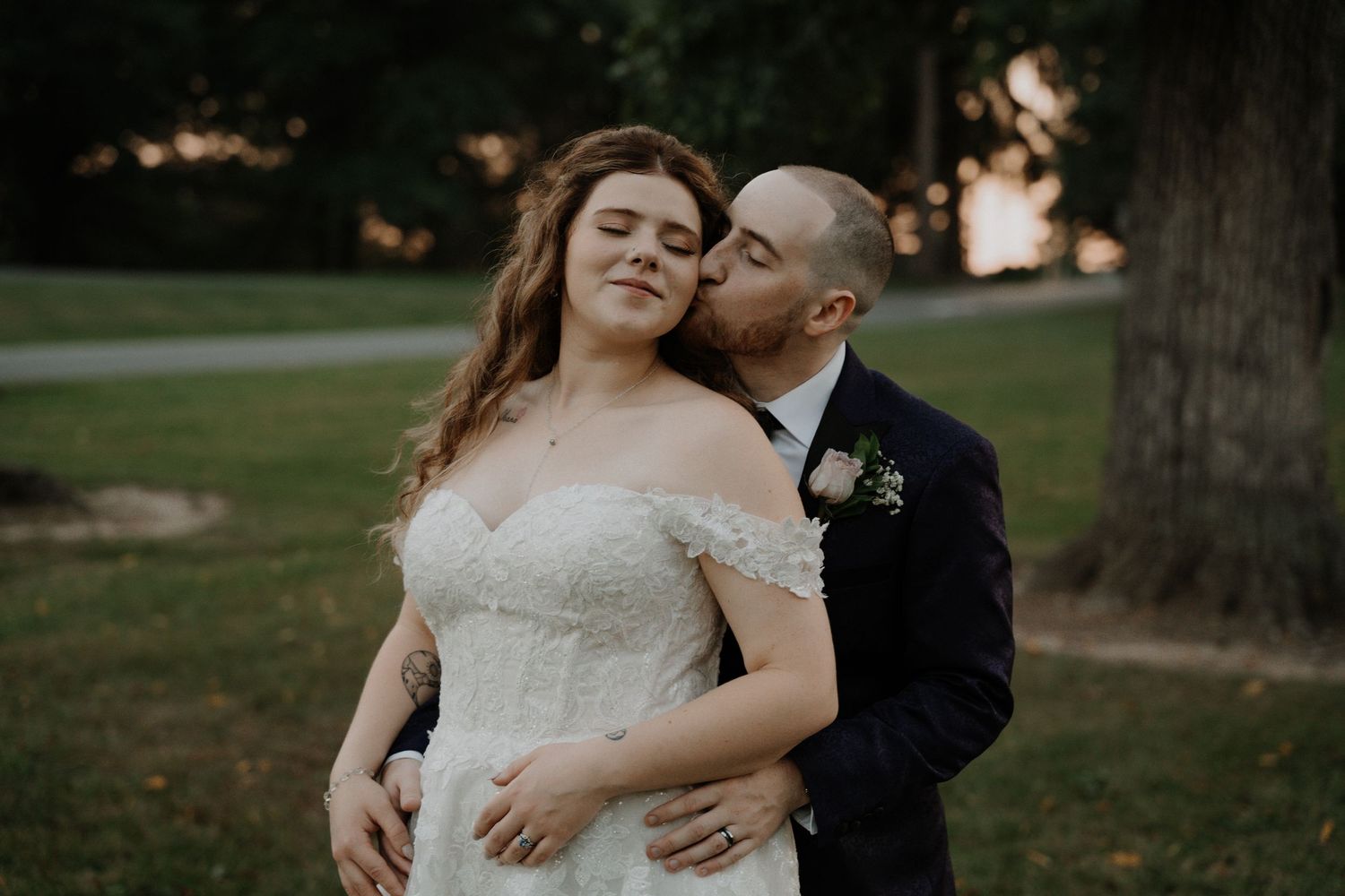 Intimate wedding portrait captured outdoors during golden hour.